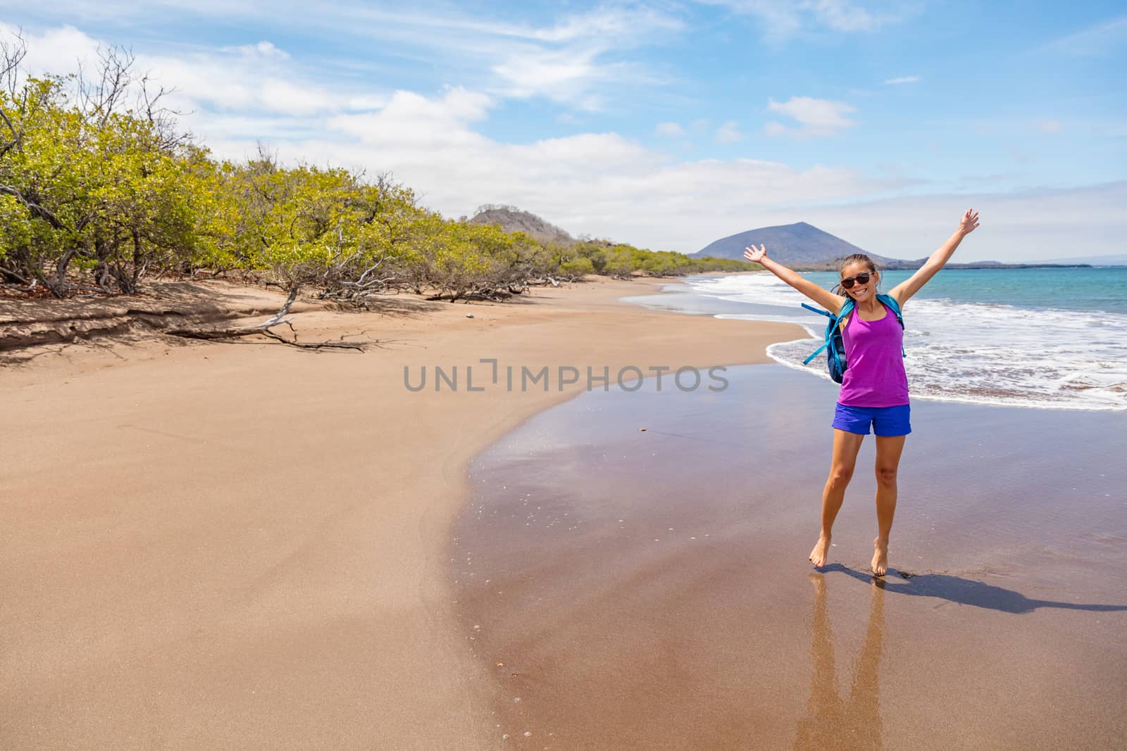 Galapagos tourist having fun on travel on Espumilla Beach, Santiago Island, Galapagos Islands, Ecuador.