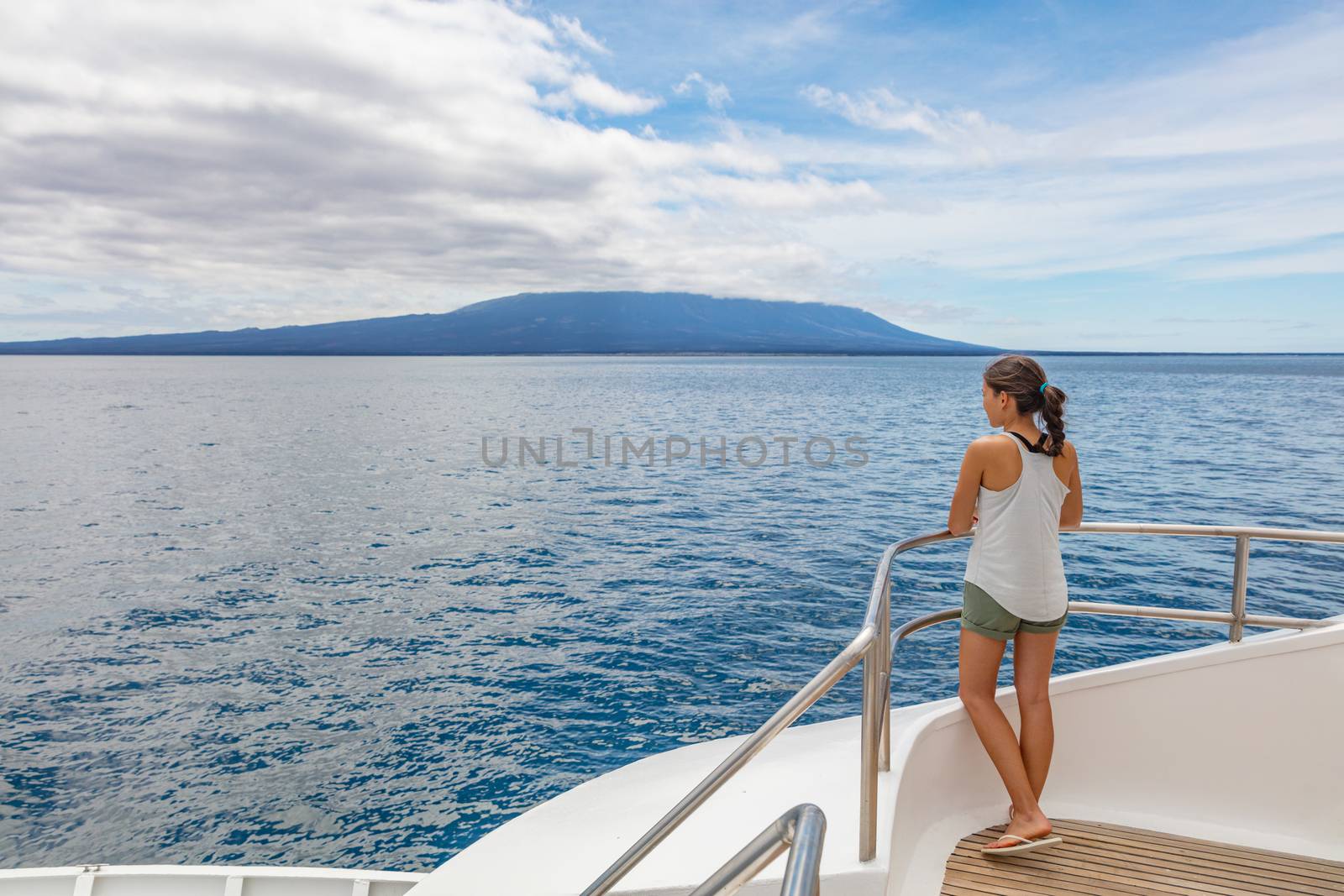 Cruise ship tourist on luxury yacht looking at sea nature landscape in Galapagos Islands while sailing on boat enjoying luxury travel lifestyle.