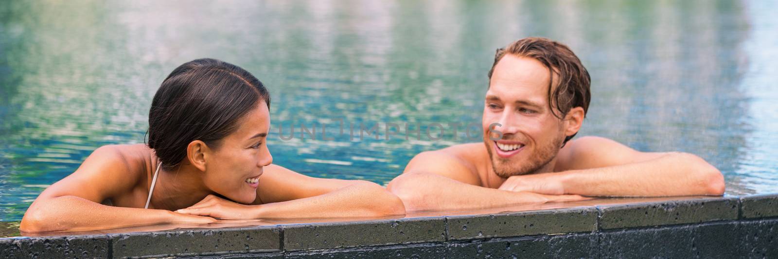 Wellness spa pool couple relaxing in hydrotherapy luxury travel resort on tropical holidays together enjoying the swim in water. Banner panorama. Hotel swimming pool by Maridav