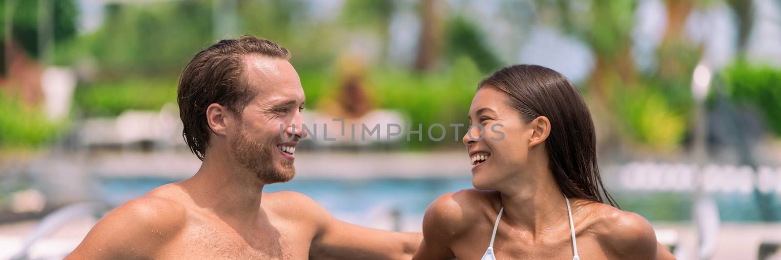 Happy couple having talking at luxury resort hotel travel beach holiday together on summer vacation. Asian woman, man relaxing by swimming pool by Maridav