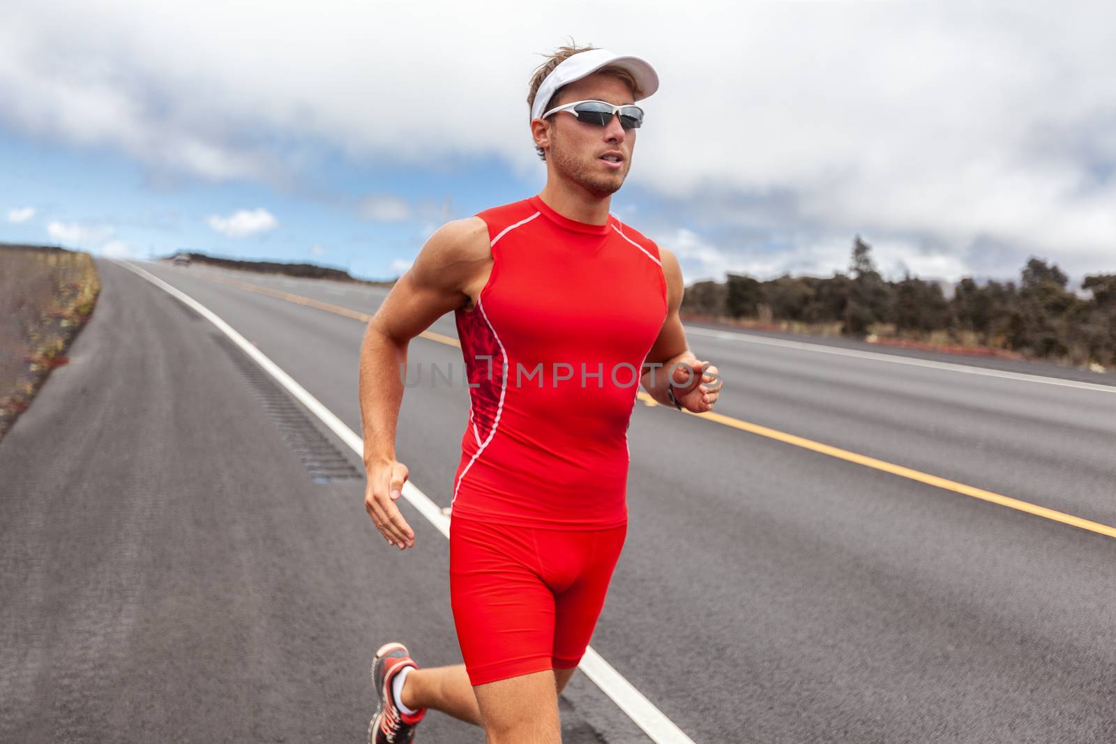 Triathlon runner man triathlete in tri running suit on road during Kona Hawaii competition race. Male athlete wearing sunglasses and cap sport outfit.