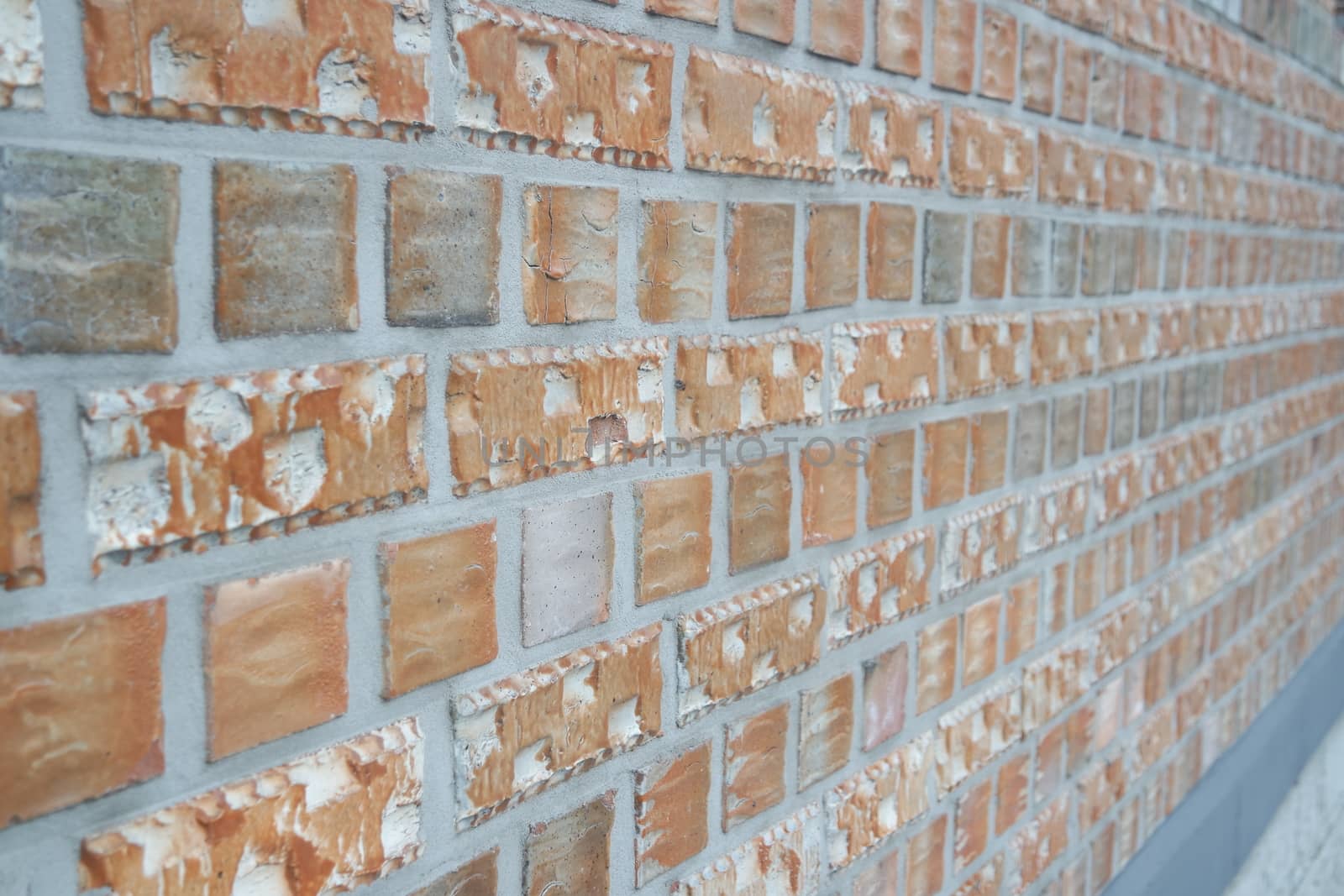 A background of a weathered old exterior brick wall in the sunshine. by Photochowk