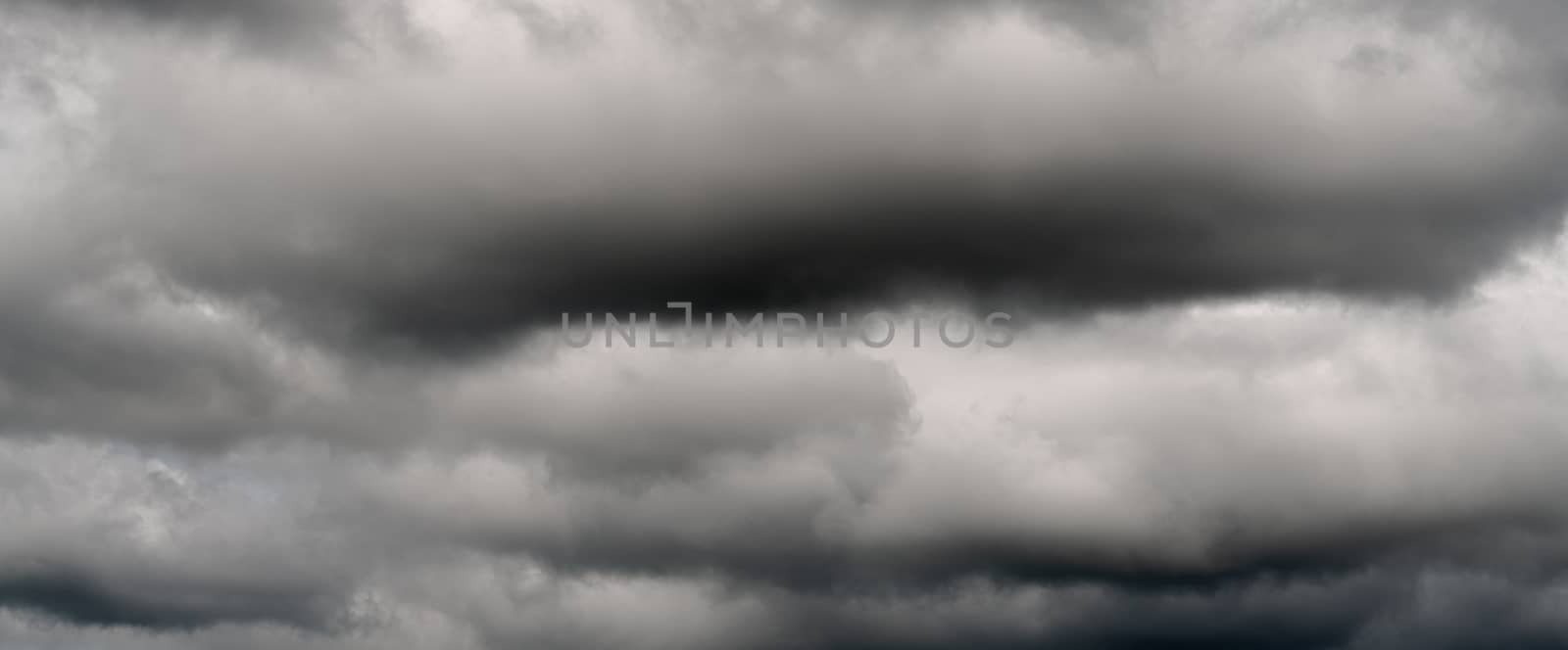 Scenery panoramic view of dramatic thunderstorm clouds in dusk sky during rain. Panorama of natural cloudiness weather background. Soft focus, blurred motion landscape.