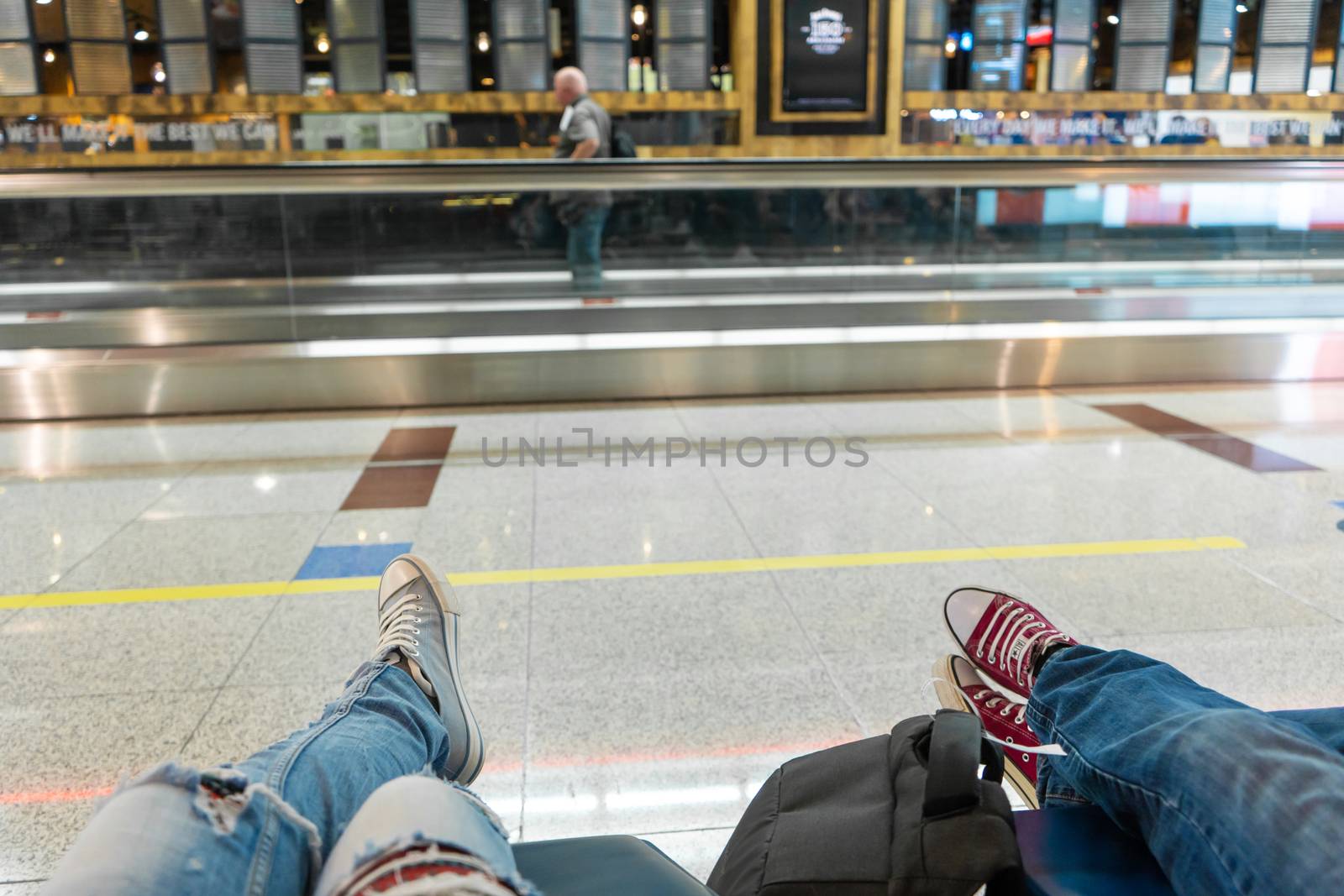 Passengers are waiting for their flight in the airport waiting area. First-person view, girl in ripped jeans by Try_my_best