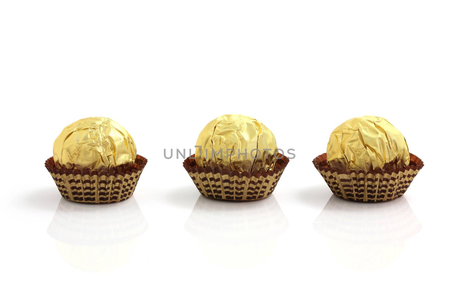 Chocolate ball in foil isolated in white background by piyato