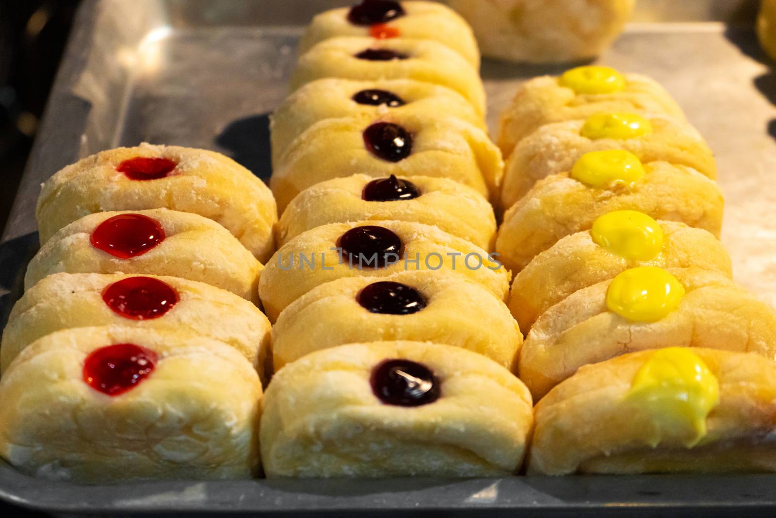 A showcase with pastries, rolls with colored fillers. by Try_my_best