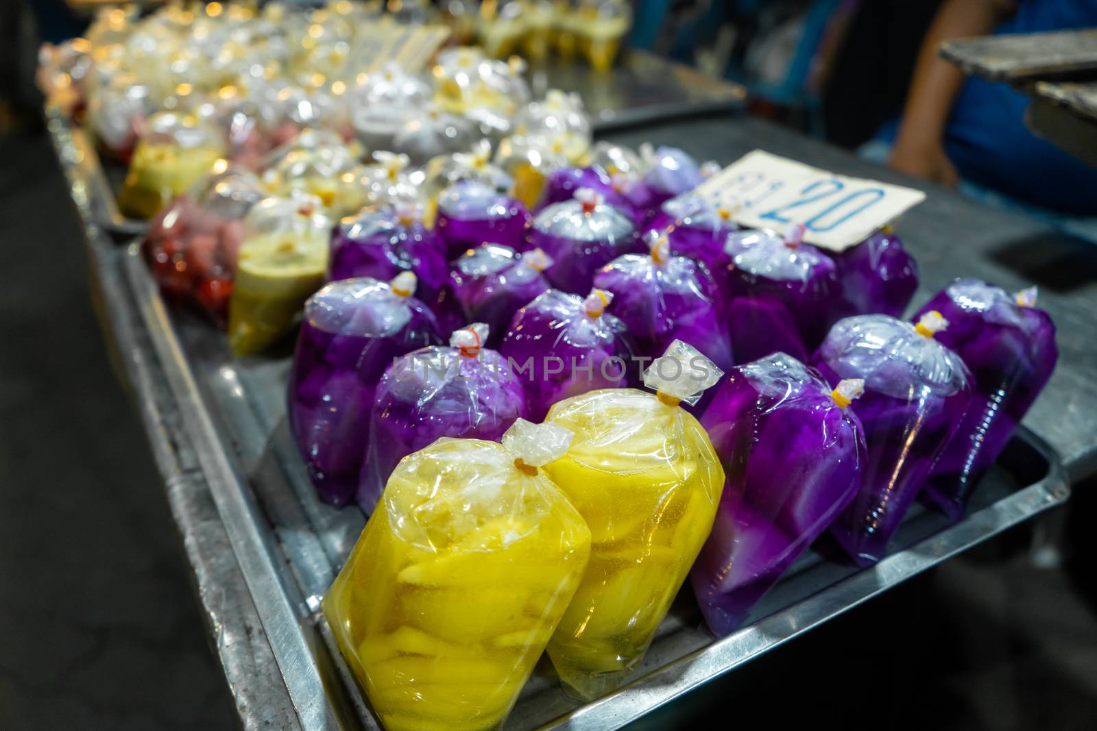 Colored desserts in plastic bags at a street food market in Asia. Unusual Asian food