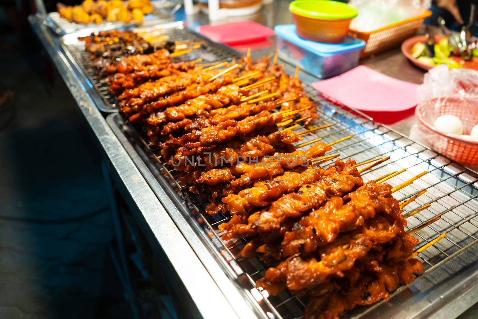 Asian food. A counter with mini kebabs of chicken skin and meat at a nightly street food market. by Try_my_best