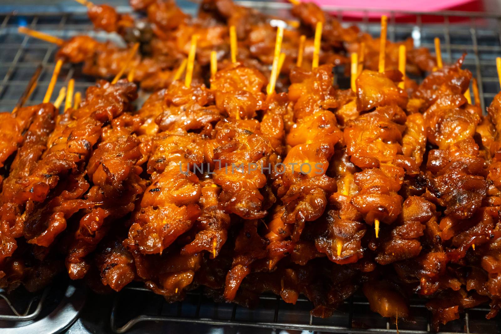 Asian food. A counter with mini kebabs of chicken skin and meat at a nightly street food market