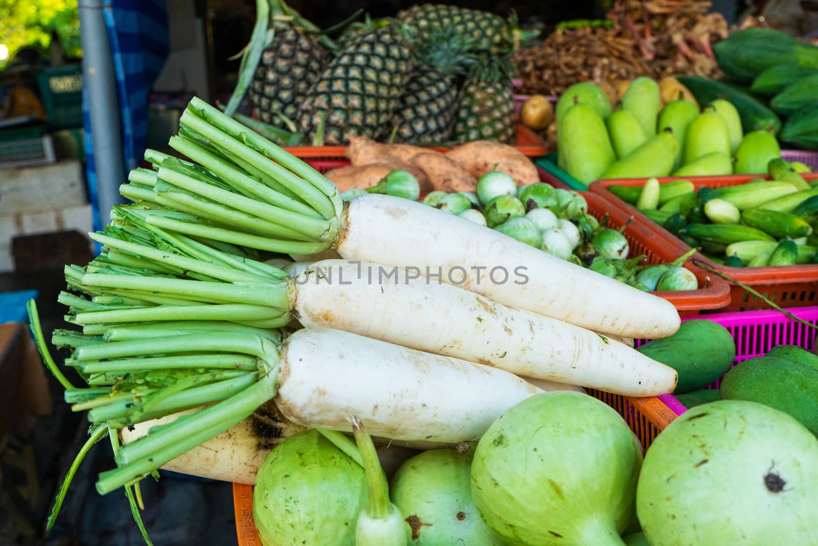 Fresh vegetables, fruits and greens on a counter in a street market.