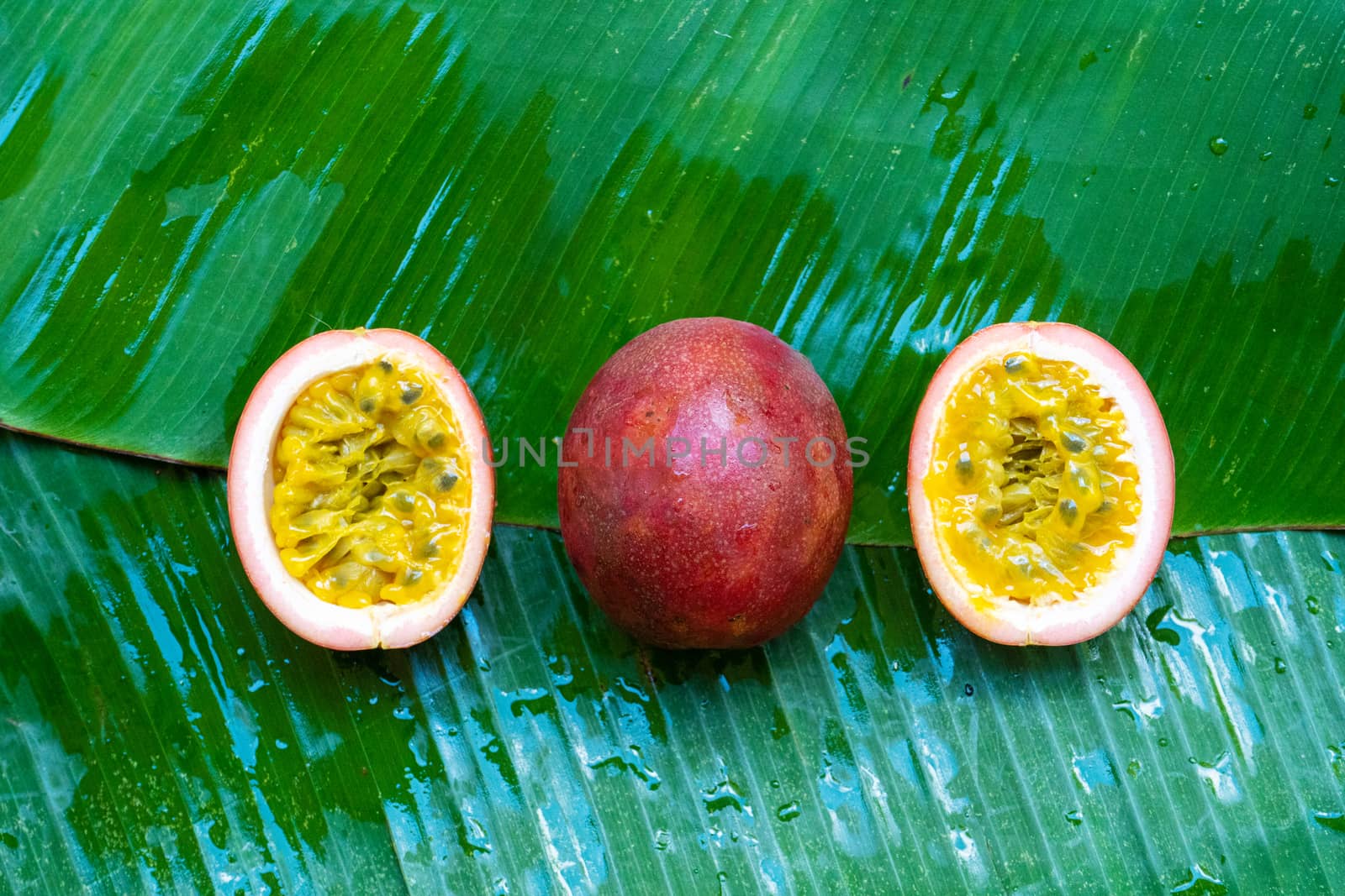 Ripe passion fruit, on a wet banana leaf. Vitamins, fruits, healthy foods by Try_my_best