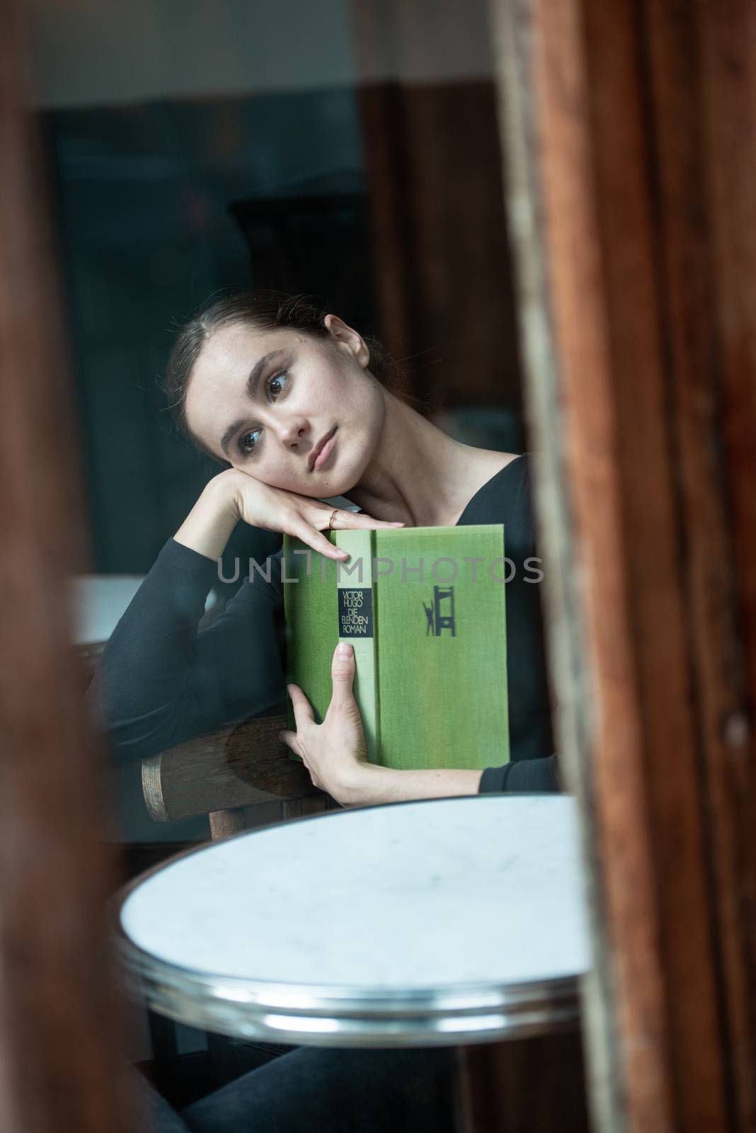 woman in coffee shop reading drinking cafe reading book by timwit