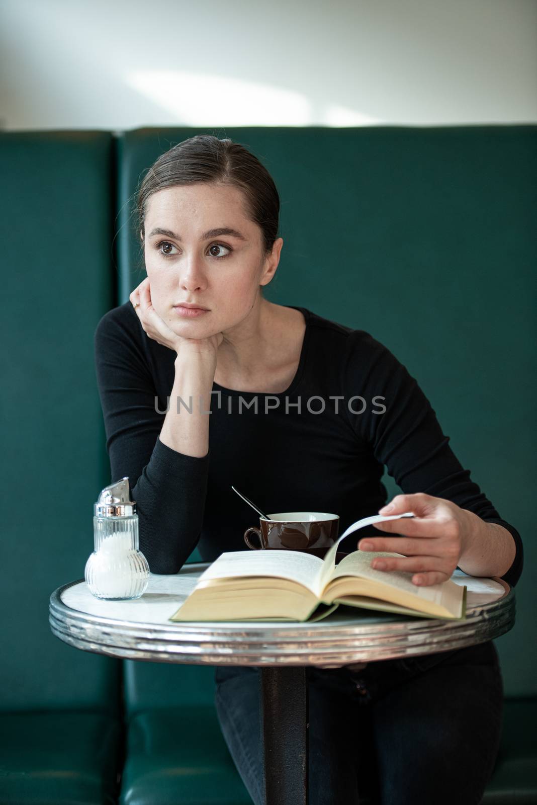 woman in coffee shop reading drinking cafe reading book by timwit