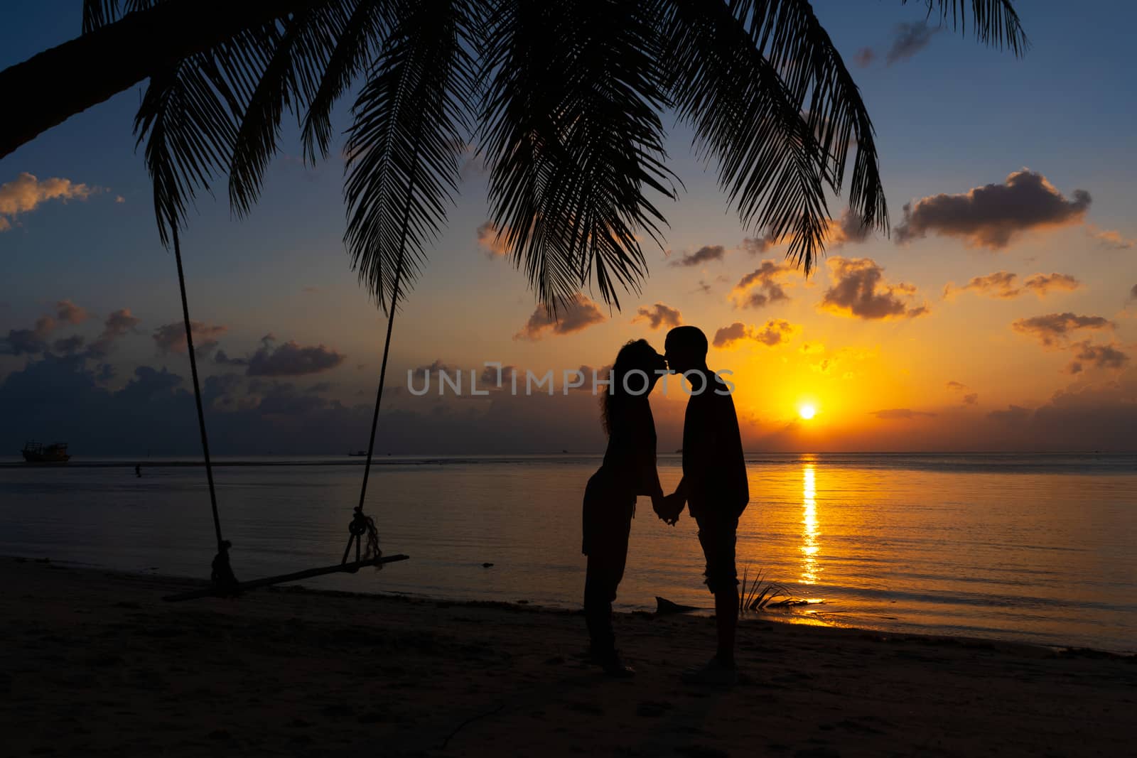 Silhouetted couple in love kisses on the beach during sunset. by Try_my_best