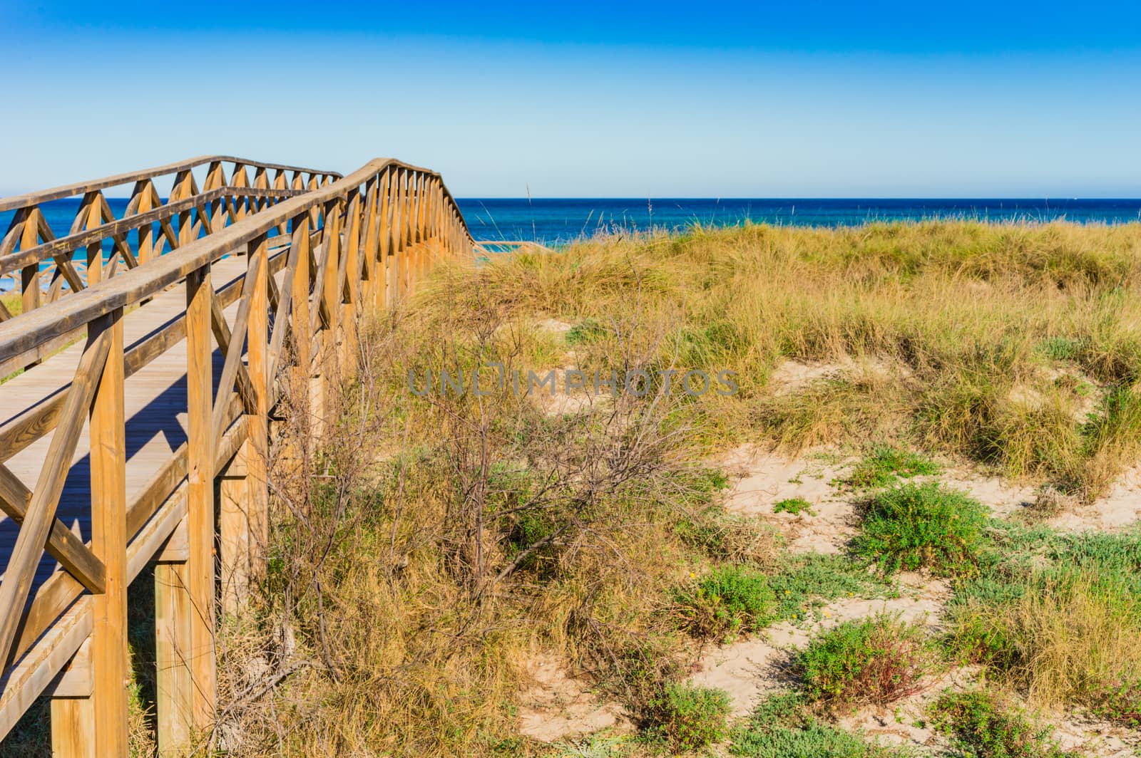 Wooden boardwalk to the beach at the bay of Alcudia, Mallorca Spain