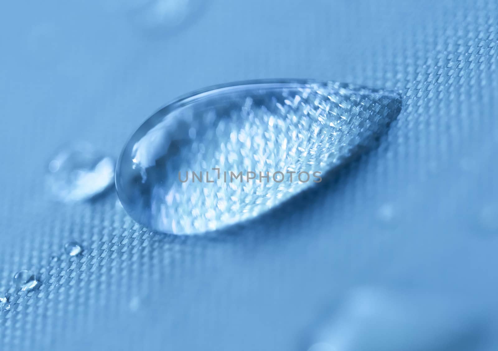 Close-up of a drop of water on a blue background. by TEERASAK