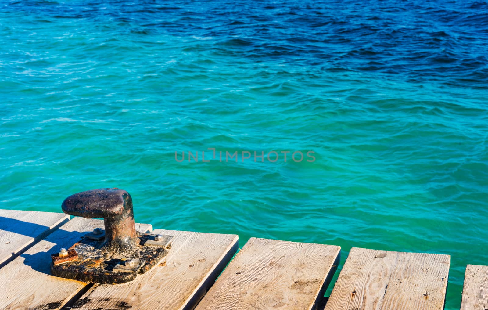 Blue sea water with wooden pier and bollard background