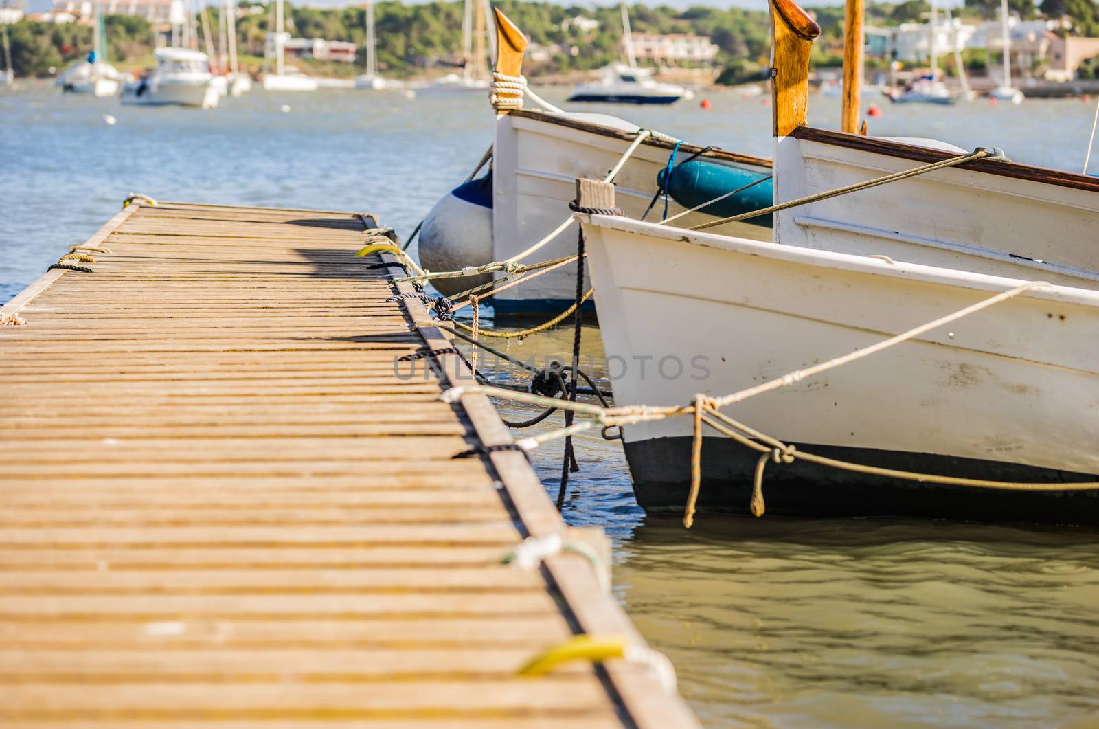 Close-up of anchoring boats on wooden jetty, nautical background