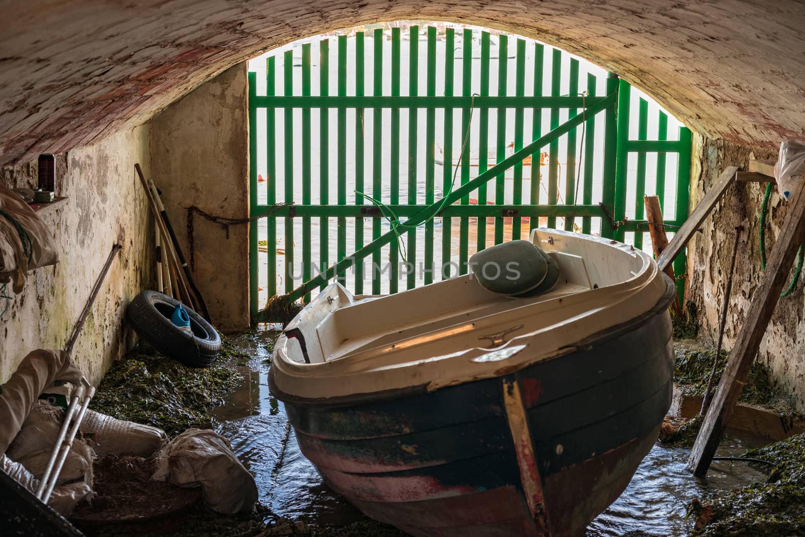 Vintage grunge boathouse with anchored old fishing boat