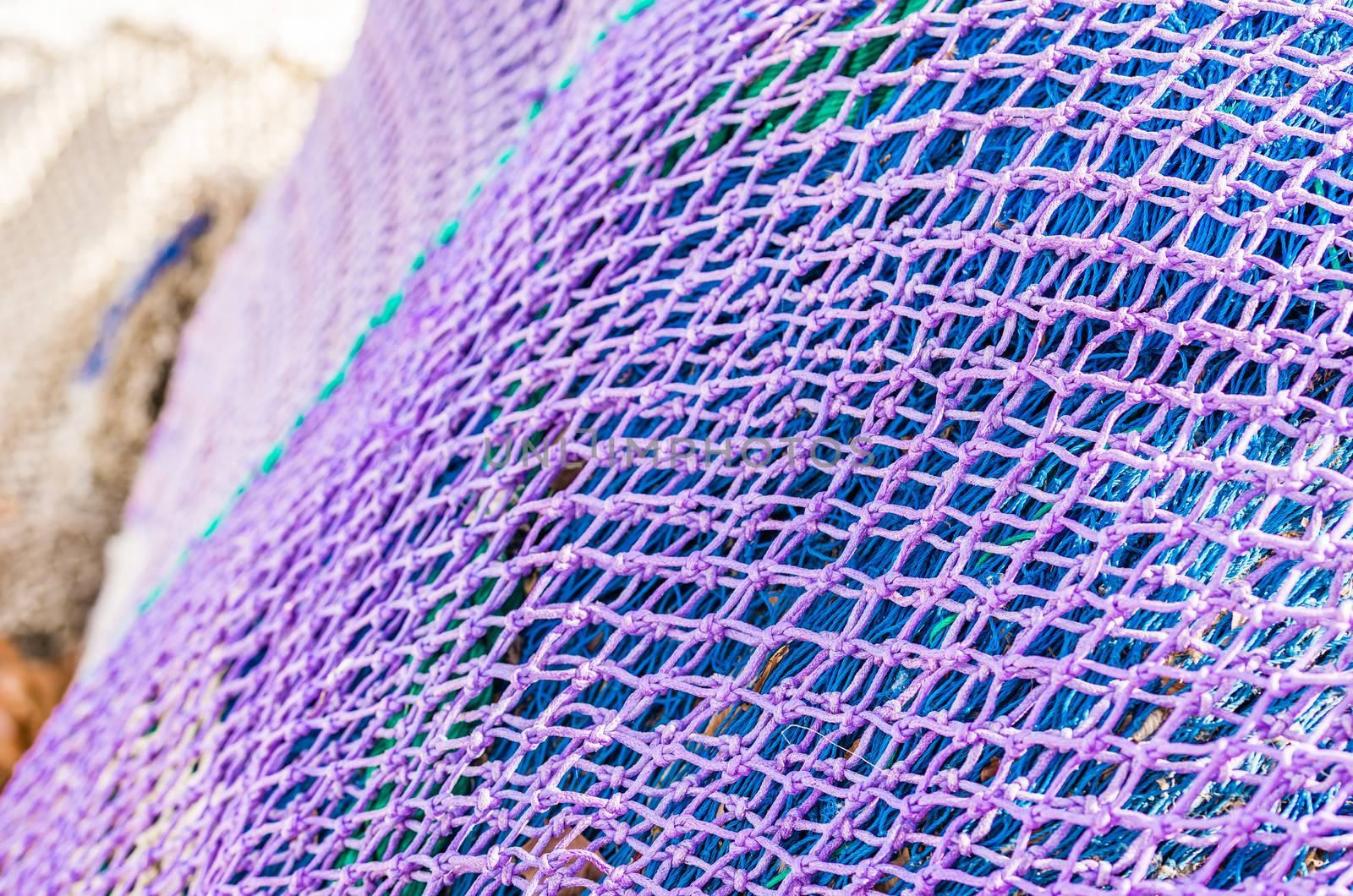 Close-up of purple and blue fish net heap, maritime background texture