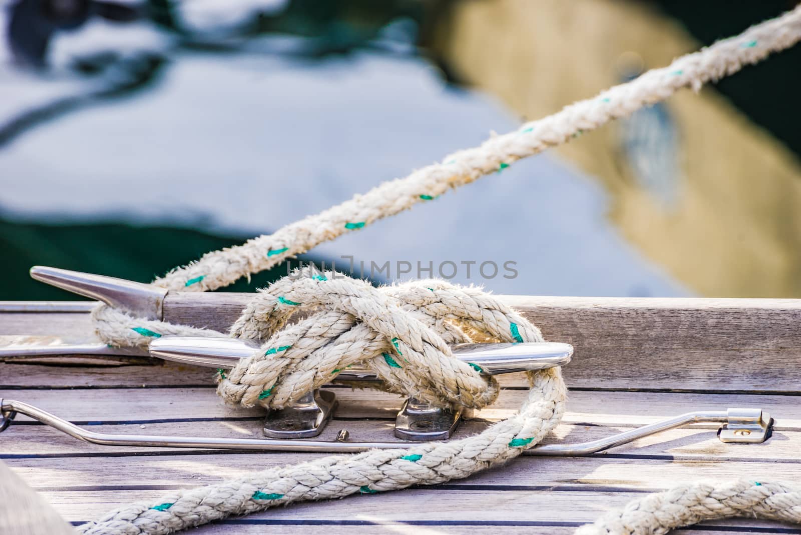 Detail view of yacht rope cleat on sailboat deck

