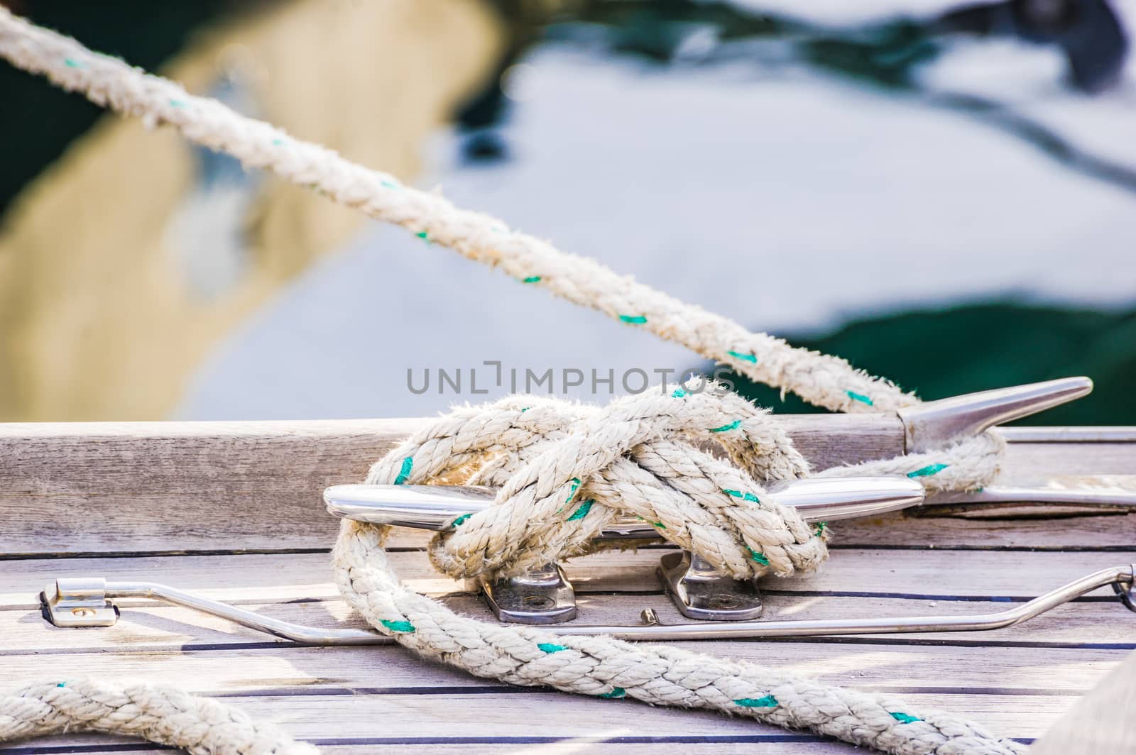 Close-up of cleat and rope on wooden boat deck