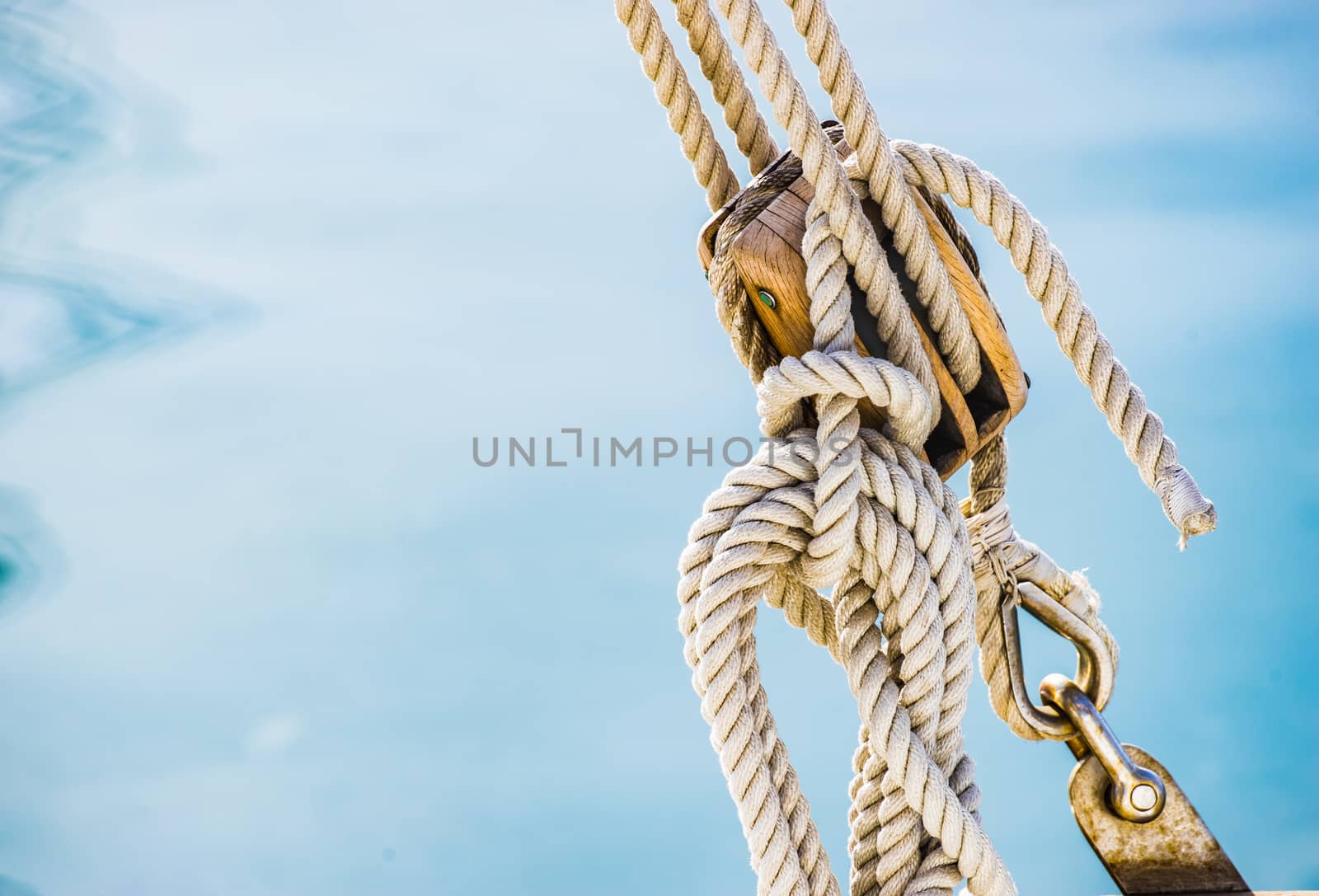 Pulley with ropes of a classic sailing boat and blue sea water 