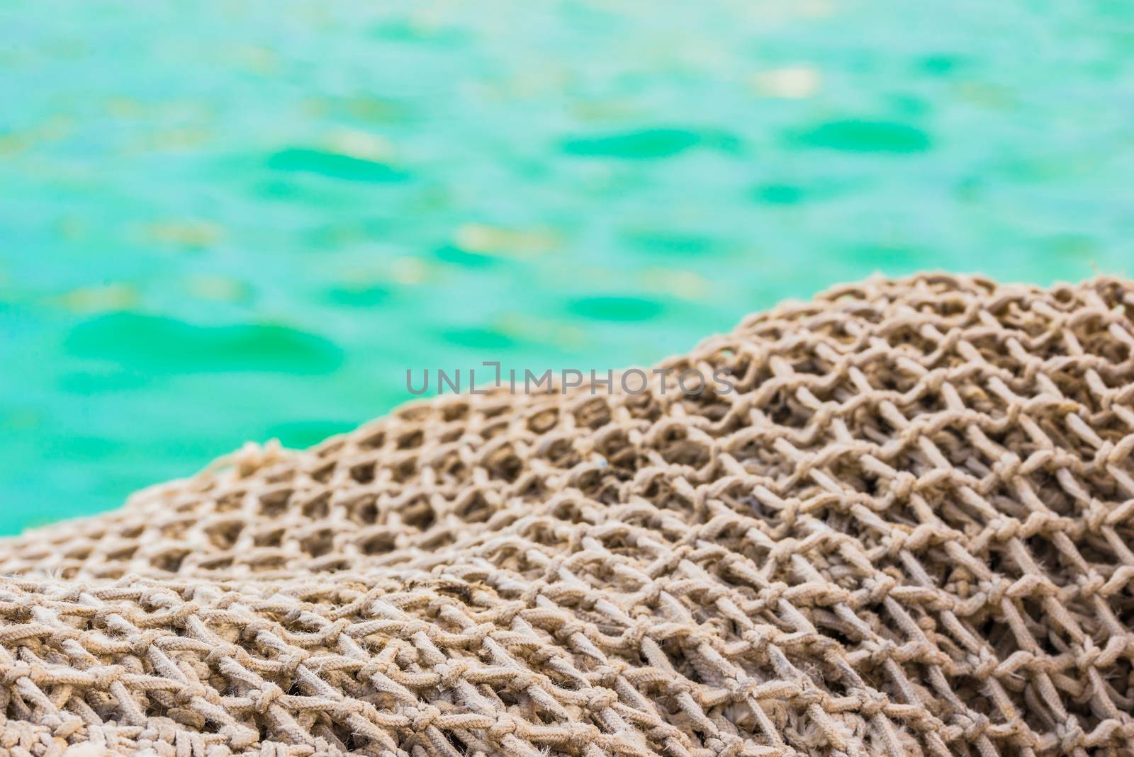 Close-up of fisher net pile at harbor with sea water background