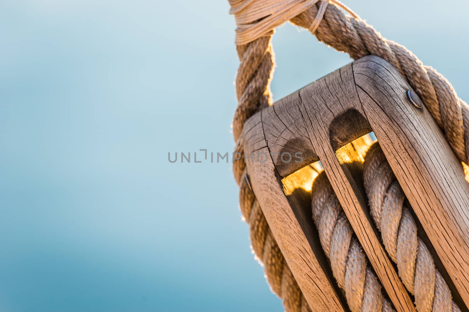 Detail image of wooden pulley with ropes of an classical sailing yacht