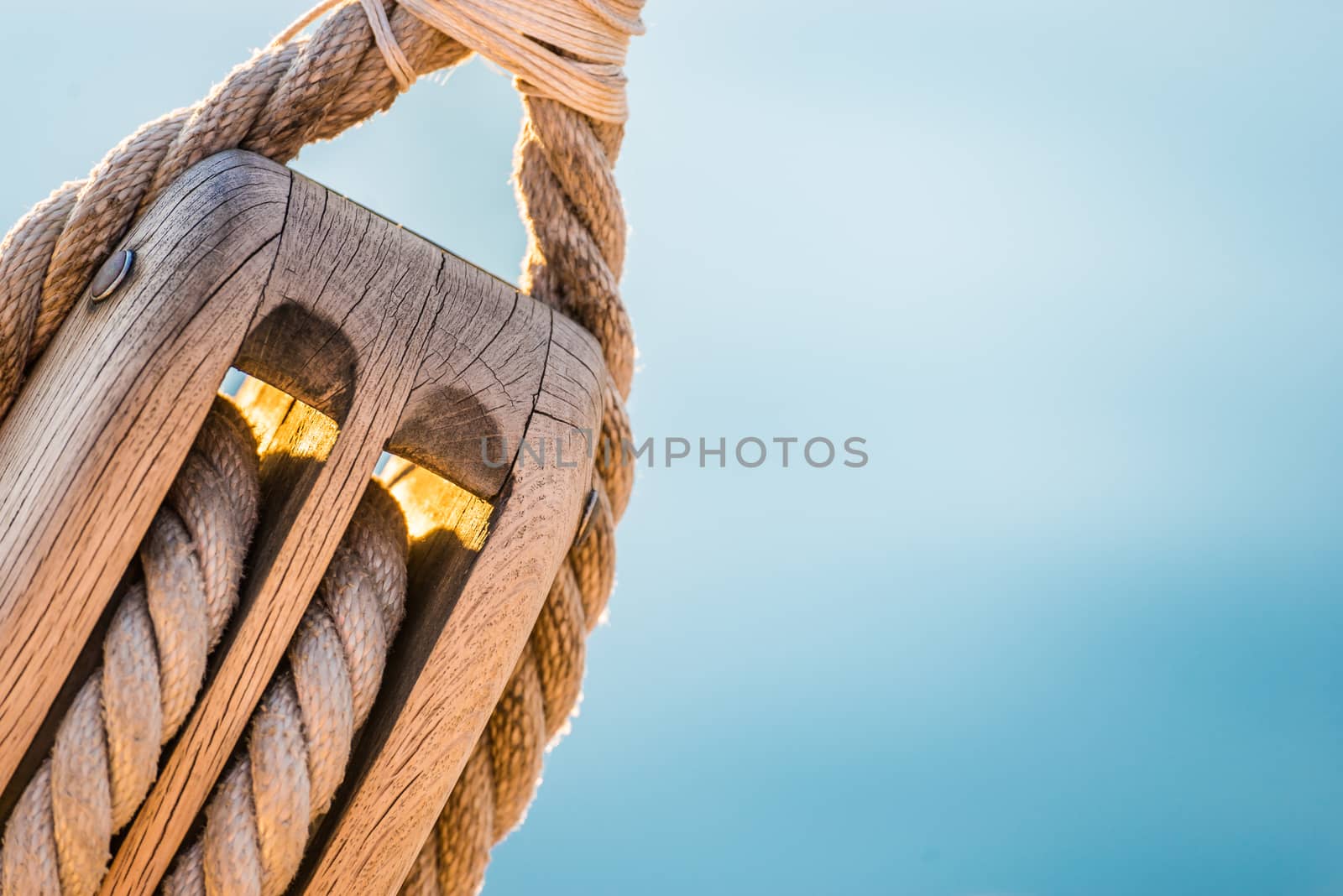 Nautical pulley with ropes of a classic sailing boat and blue sea water 