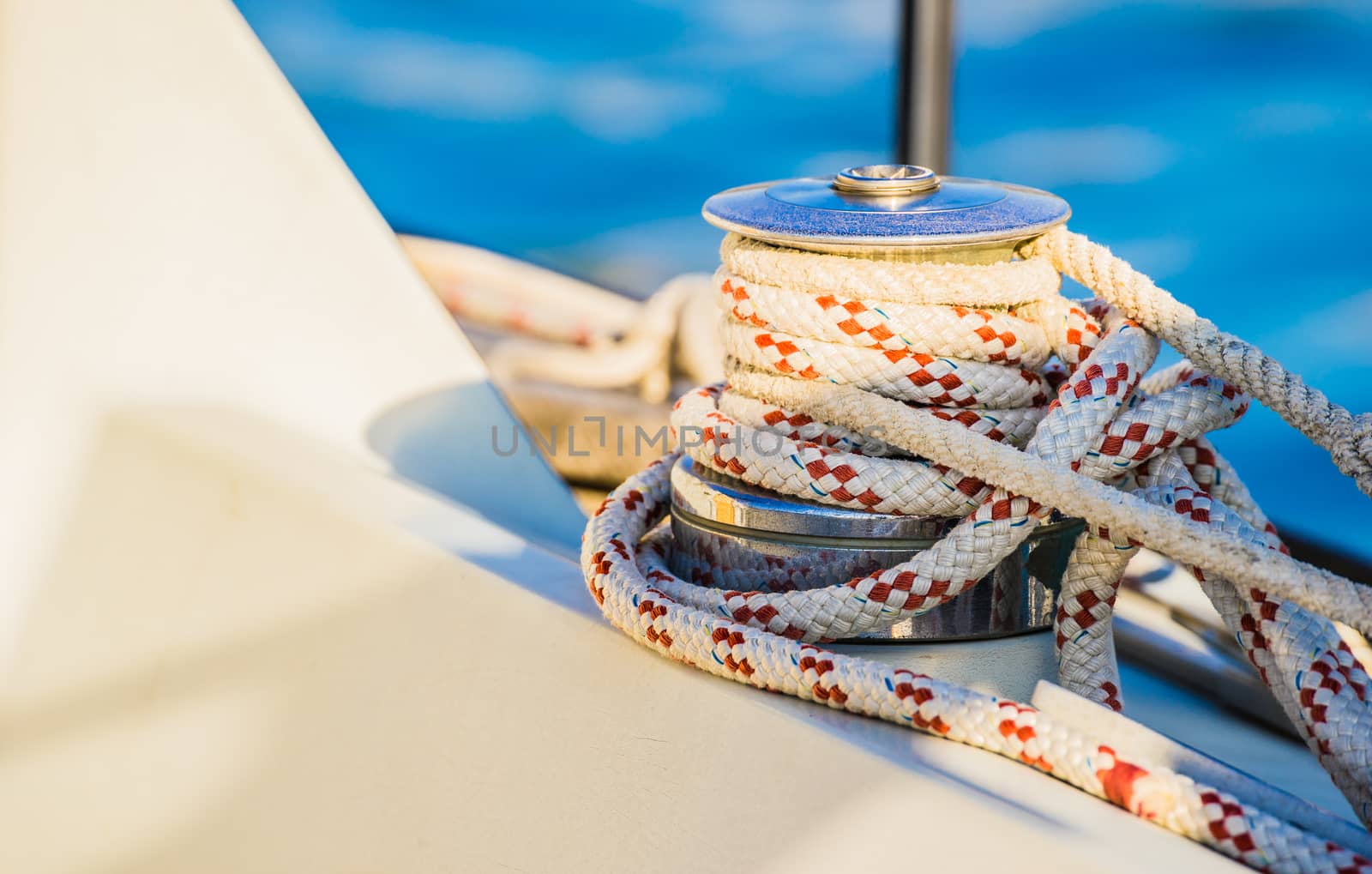 Close-up of winch with nautical rope on boat deck of sailing yacht