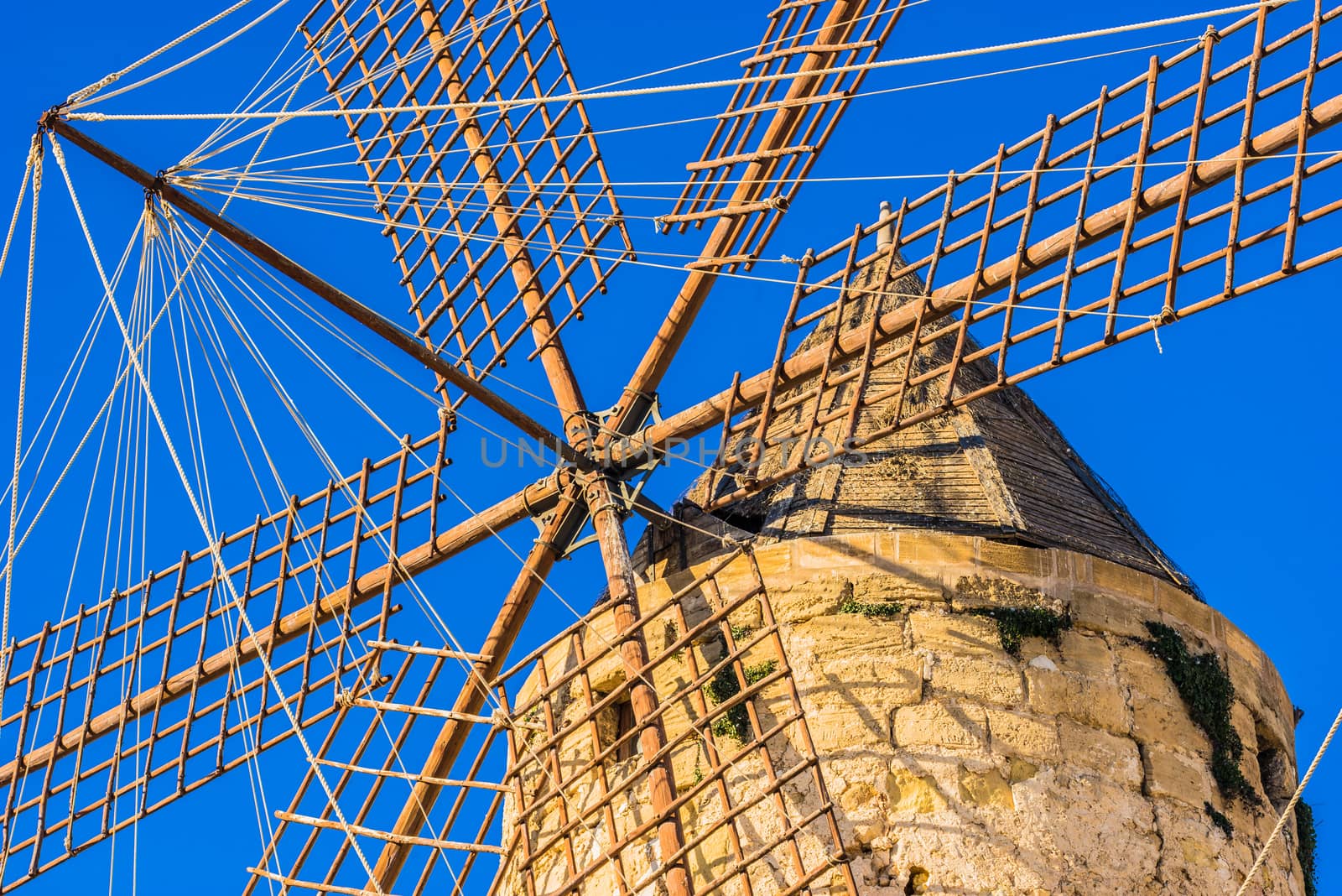 Close-up of old historic windmill wings with blue sky background