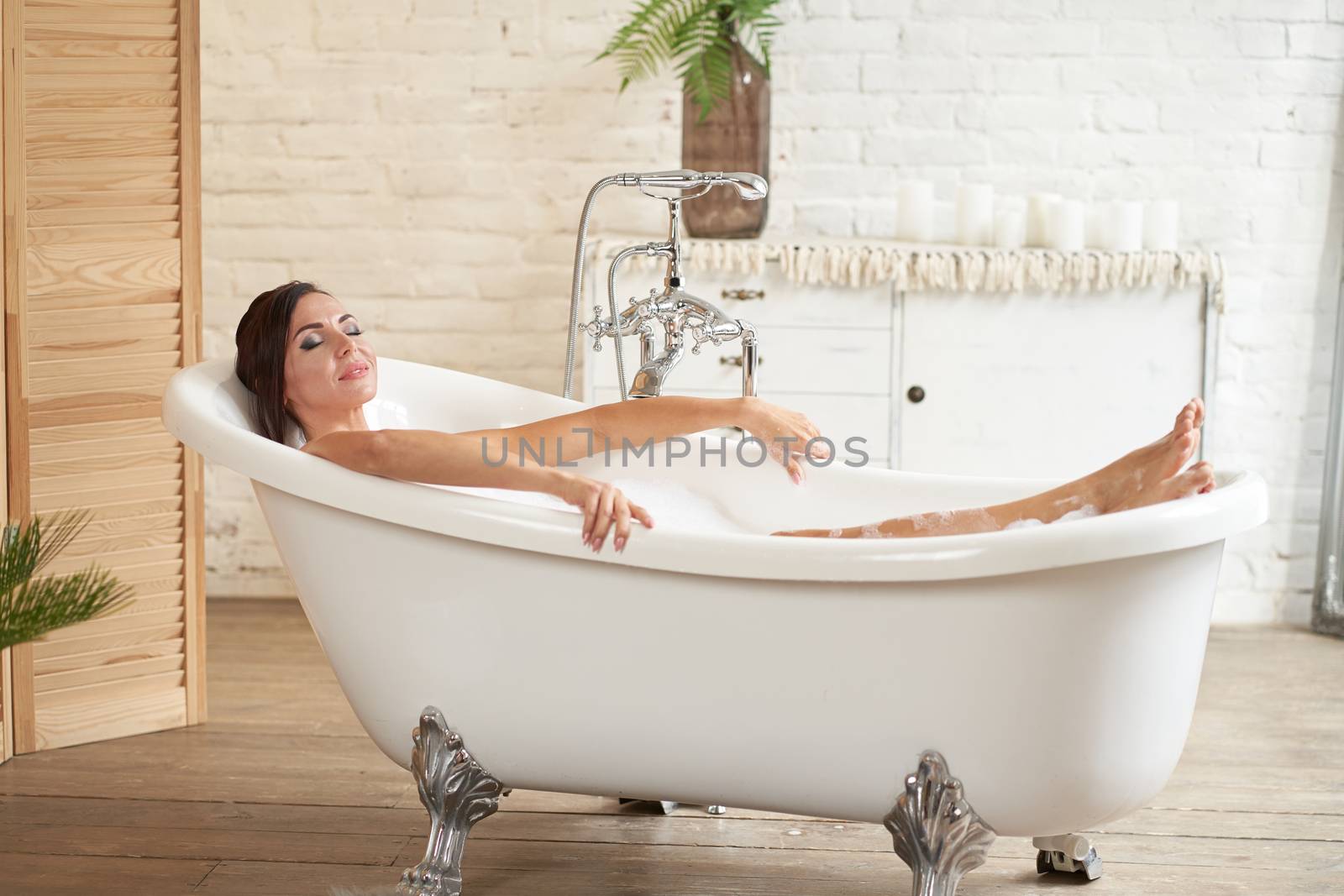Gorgeous beautiful female takes a bath. Relax in a bubble bath
