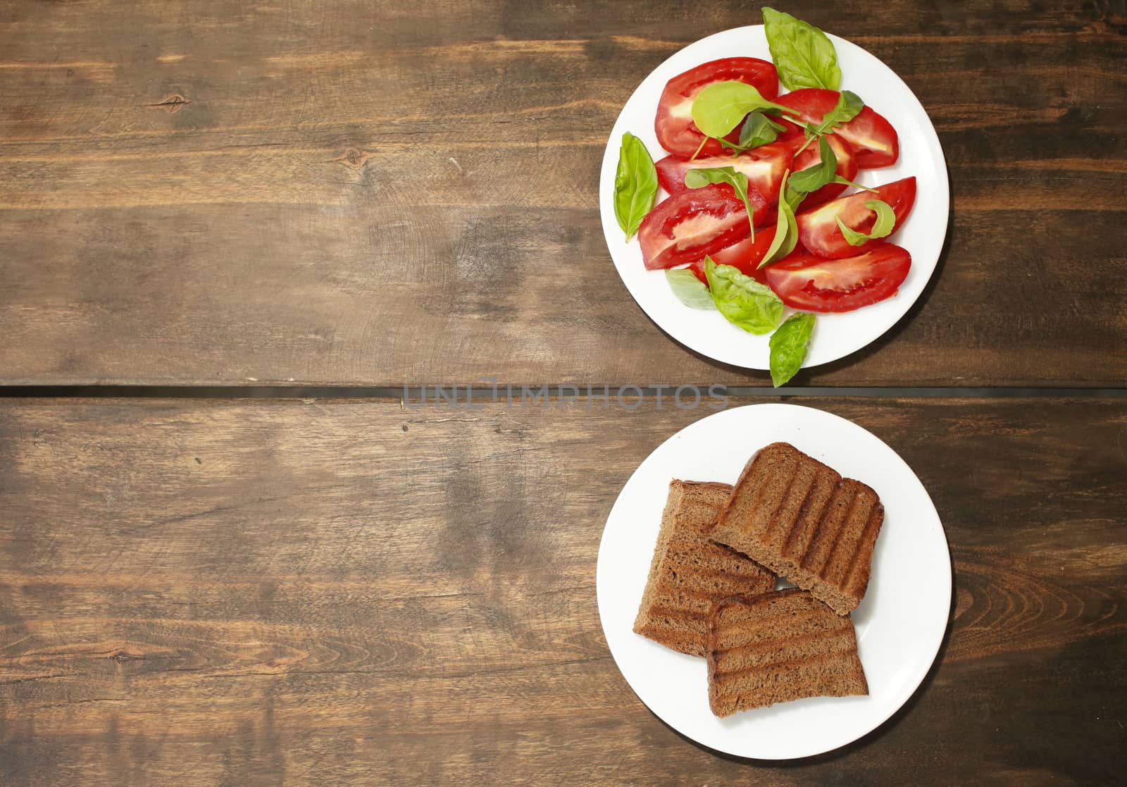 Sliced tomatoes with lettuce on a white plate. Fresh bread toast. Healthy eating concept. High quality photo
