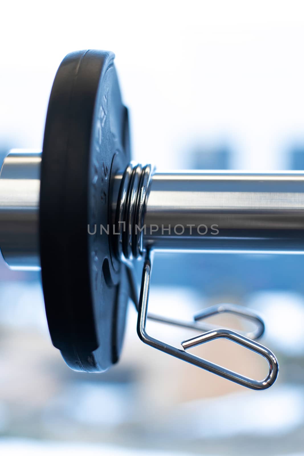Closeup weight plate fixed on barbell in gym by Try_my_best