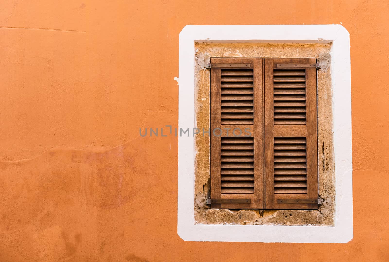 Old mediterranean window shutters and wall background 