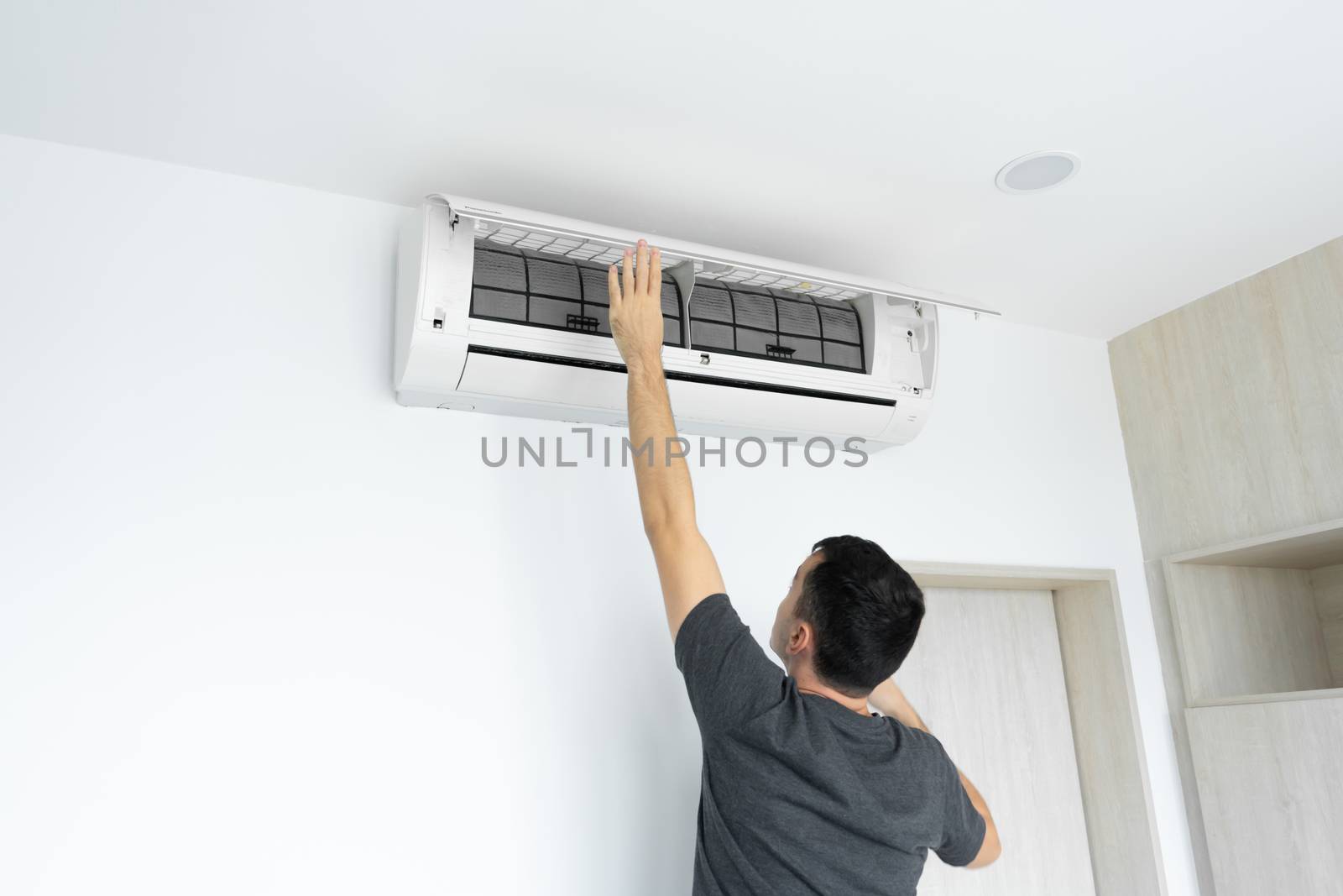 The guy cleans the filter of the home air conditioner from dust. Very dirty air conditioner filter. Climate equipment care. by Try_my_best