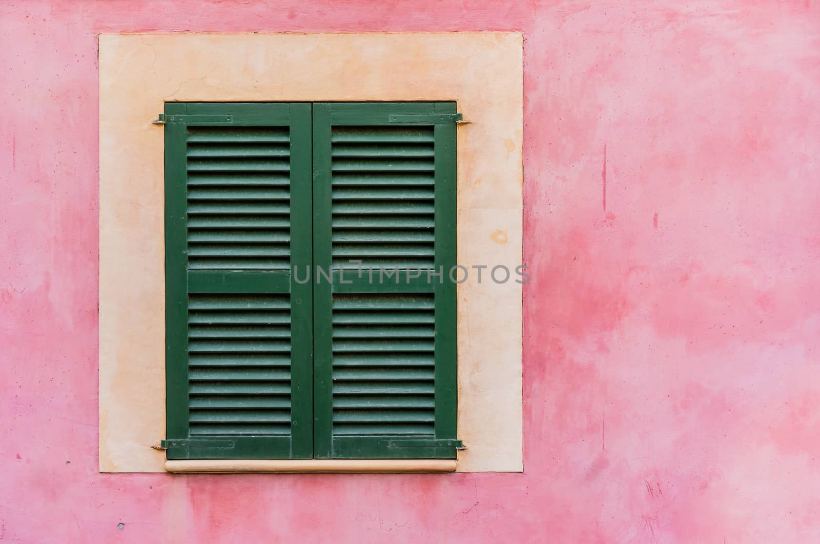 Detail view of green window shutters and mediterranean wall