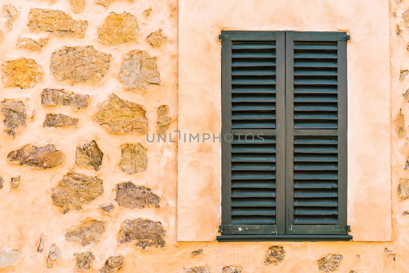 Detail view of wooden window shutters and wall