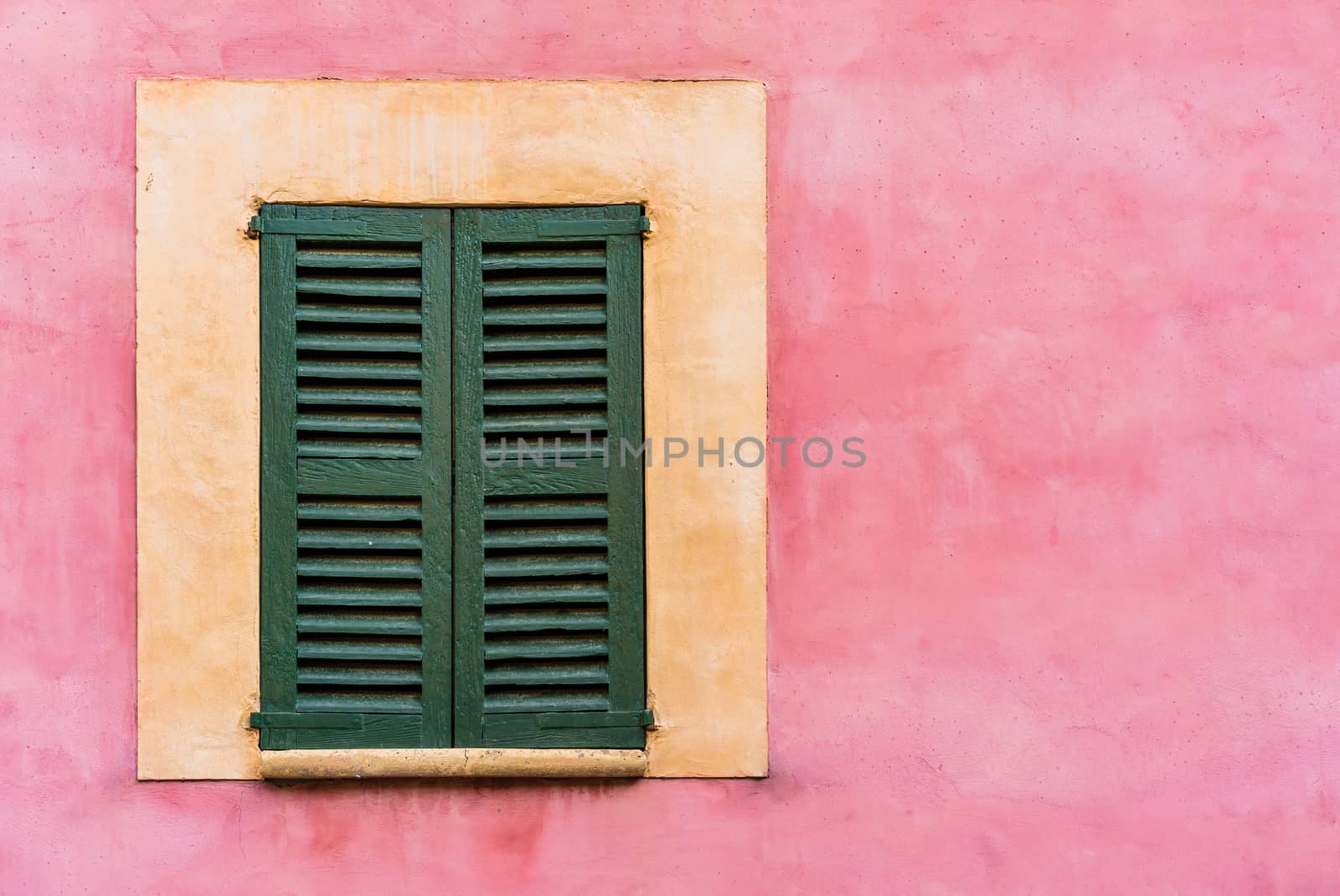 Old mediterranean window shutters and wall background