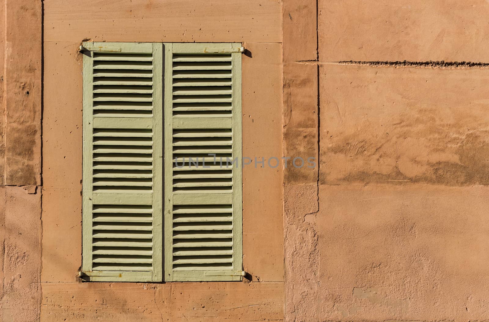 Old mediterranean window shutters and wall background 