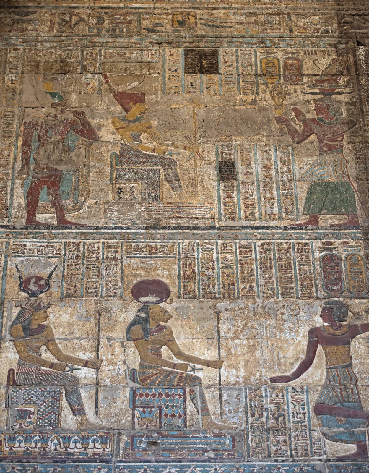 Hieroglypic colourful carving paintings on wall at the ancient egyptian temple of Khnum in Esna with god Sekhmet