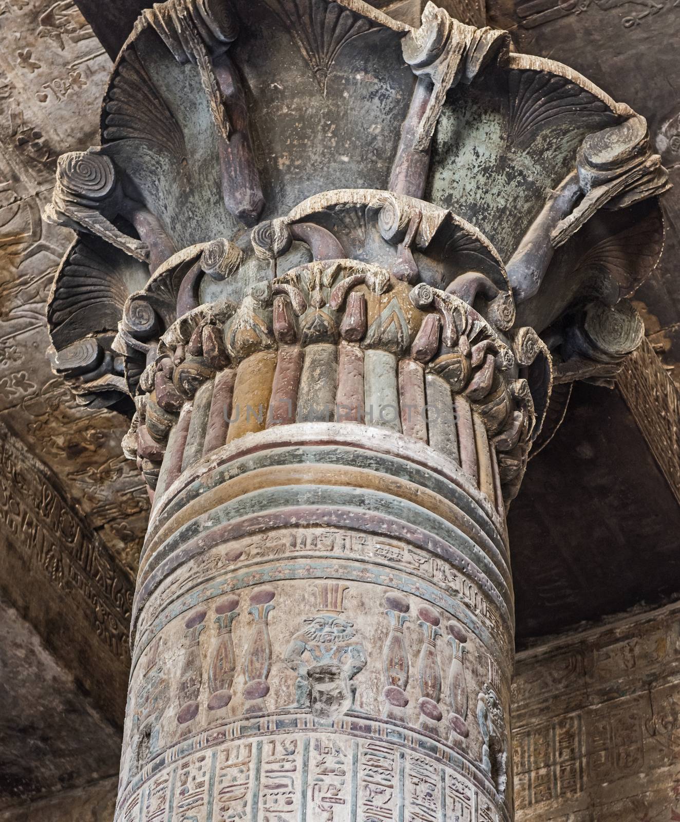 Columns in the ancient egyptian temple of Khnum at Esna with painted hieroglyphic carvings showing the god Bes