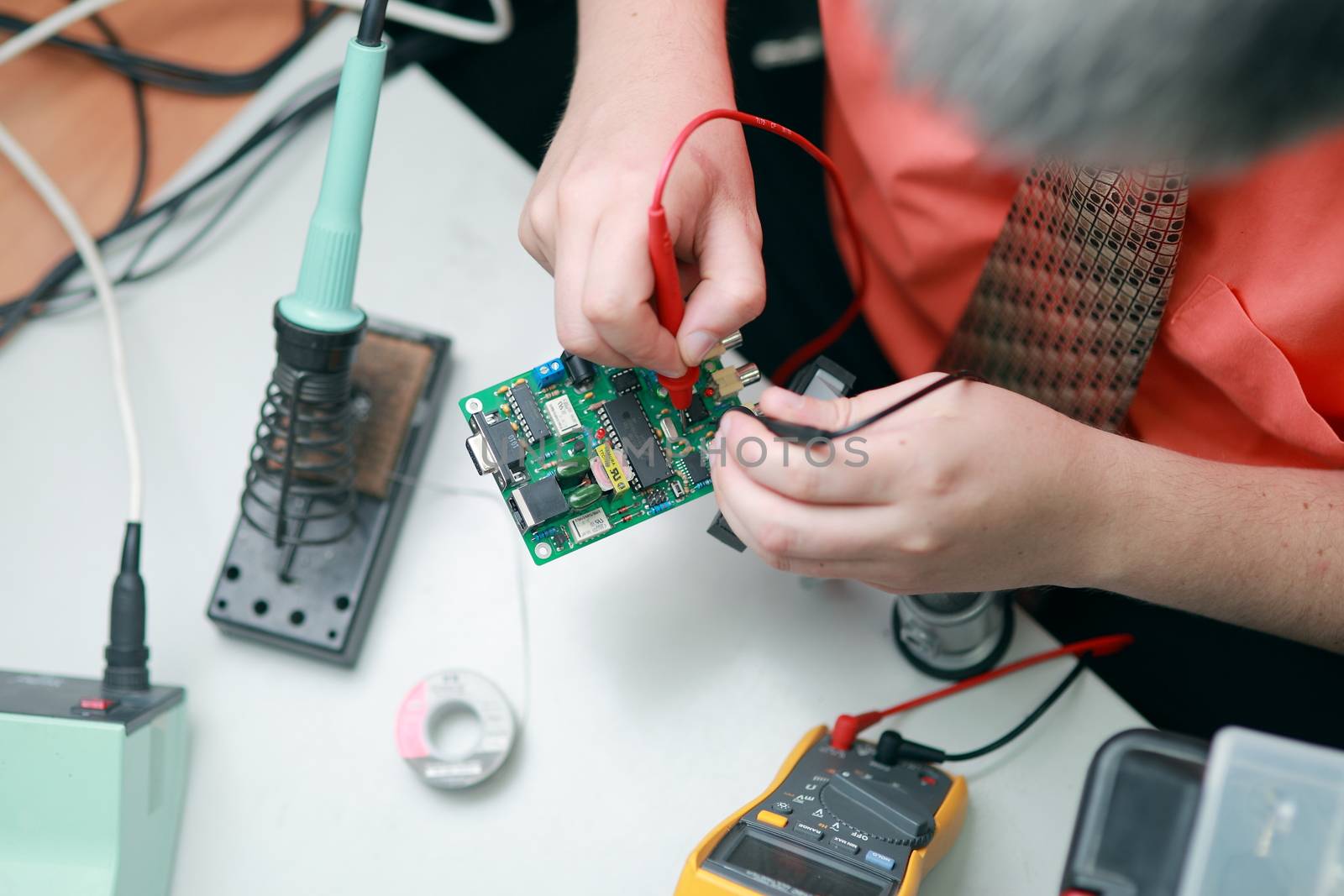 The hands of a man are engaged in the repair of tools, the manufacture of electronics Services, Manual assembly of the soldering circuit board. High quality photo