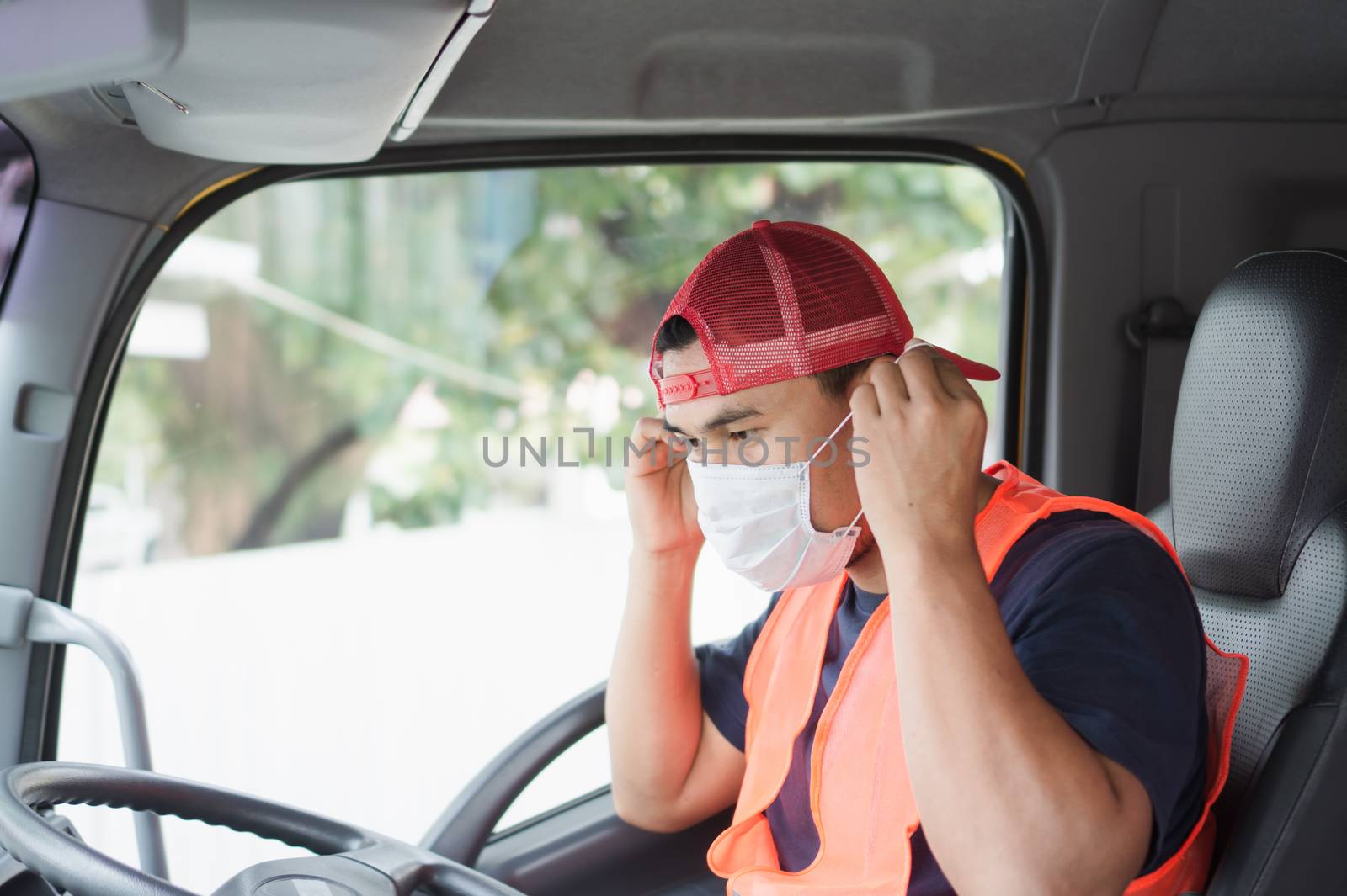Professional worker, truck driver, middle-aged Asian man wearing protective mask And safety vests For a long transportation business