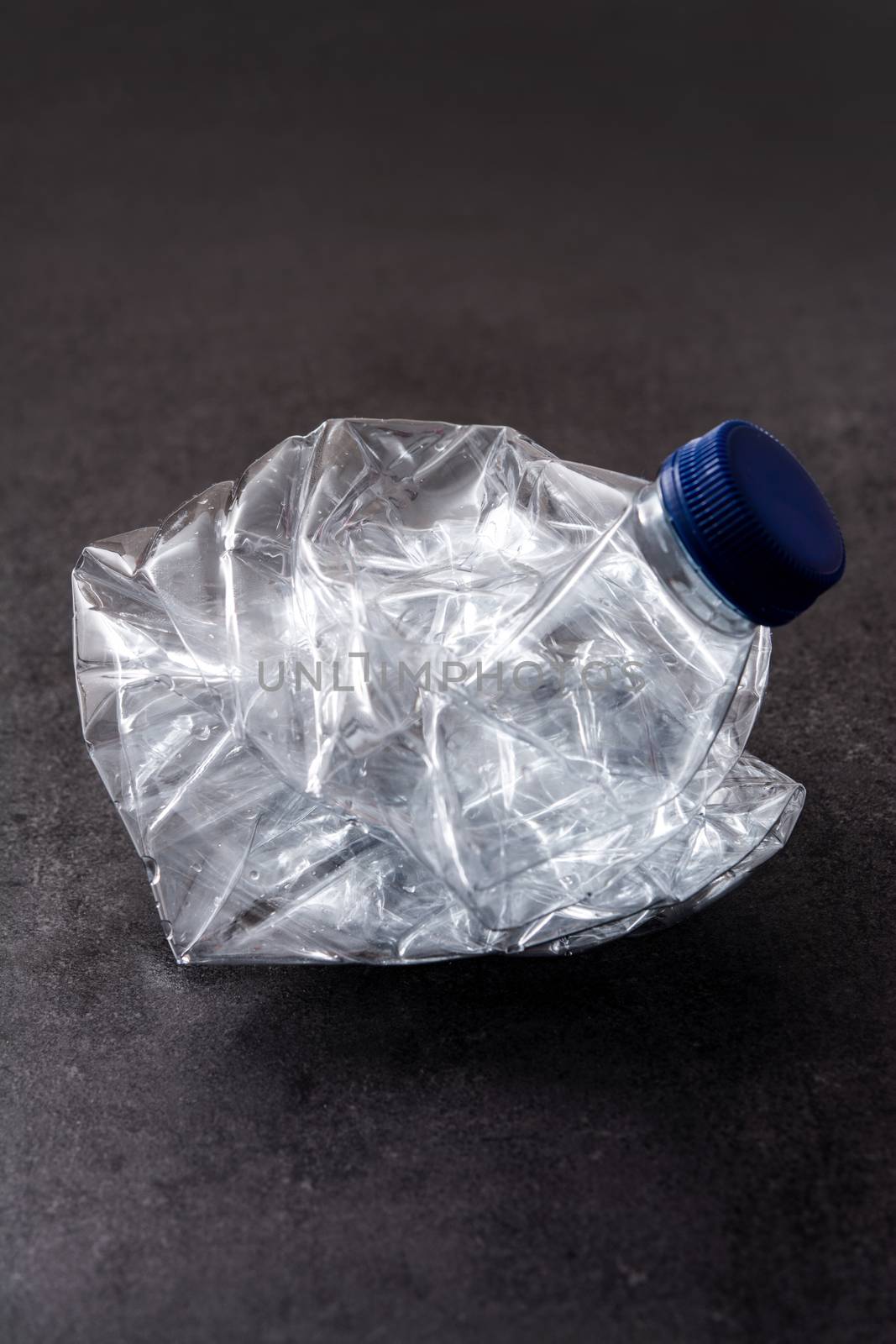 Disposable waste plastic bottle on black background