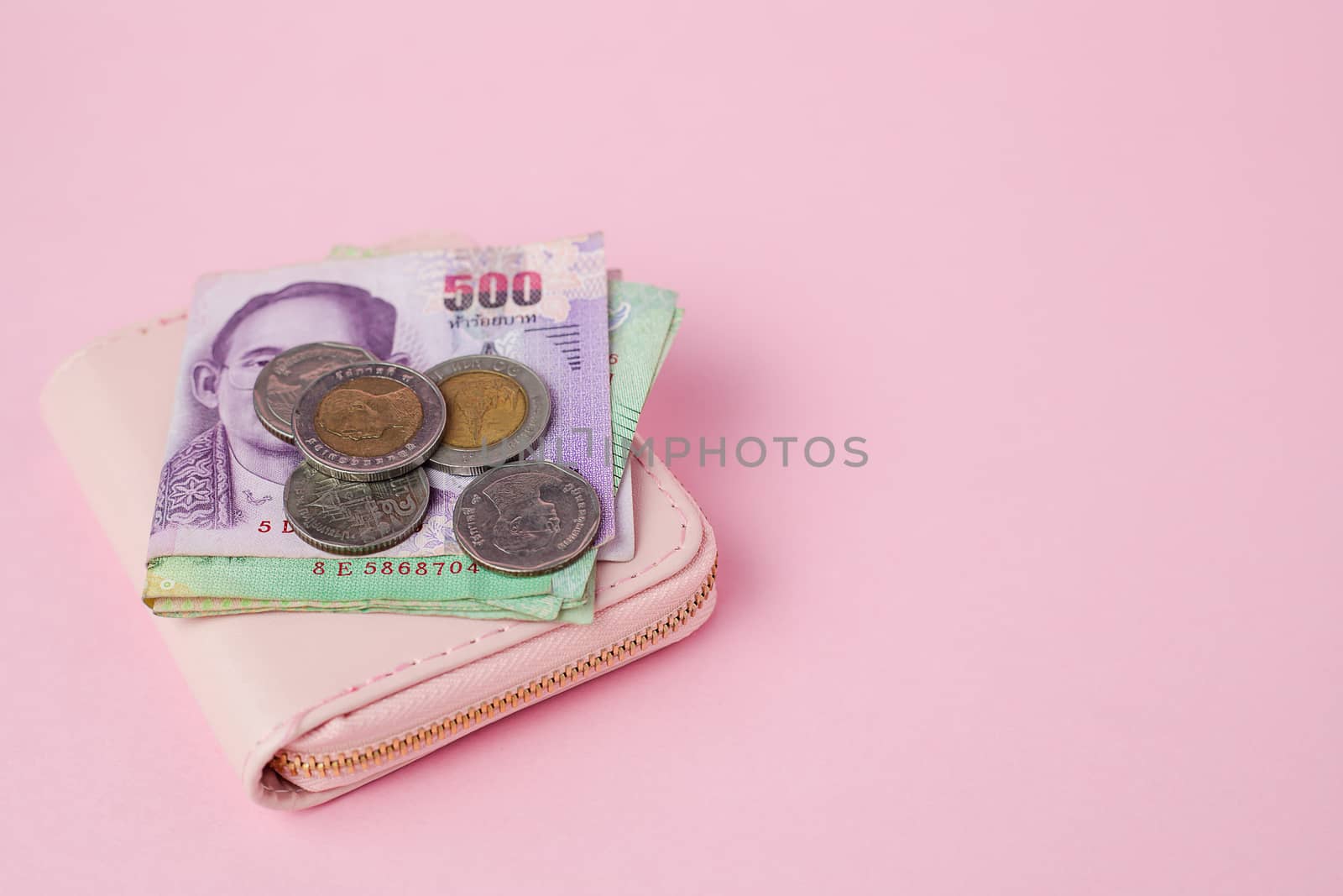 Thai currency banknote and money coins with wallet on pink background for business, finance, investment and saving money concept