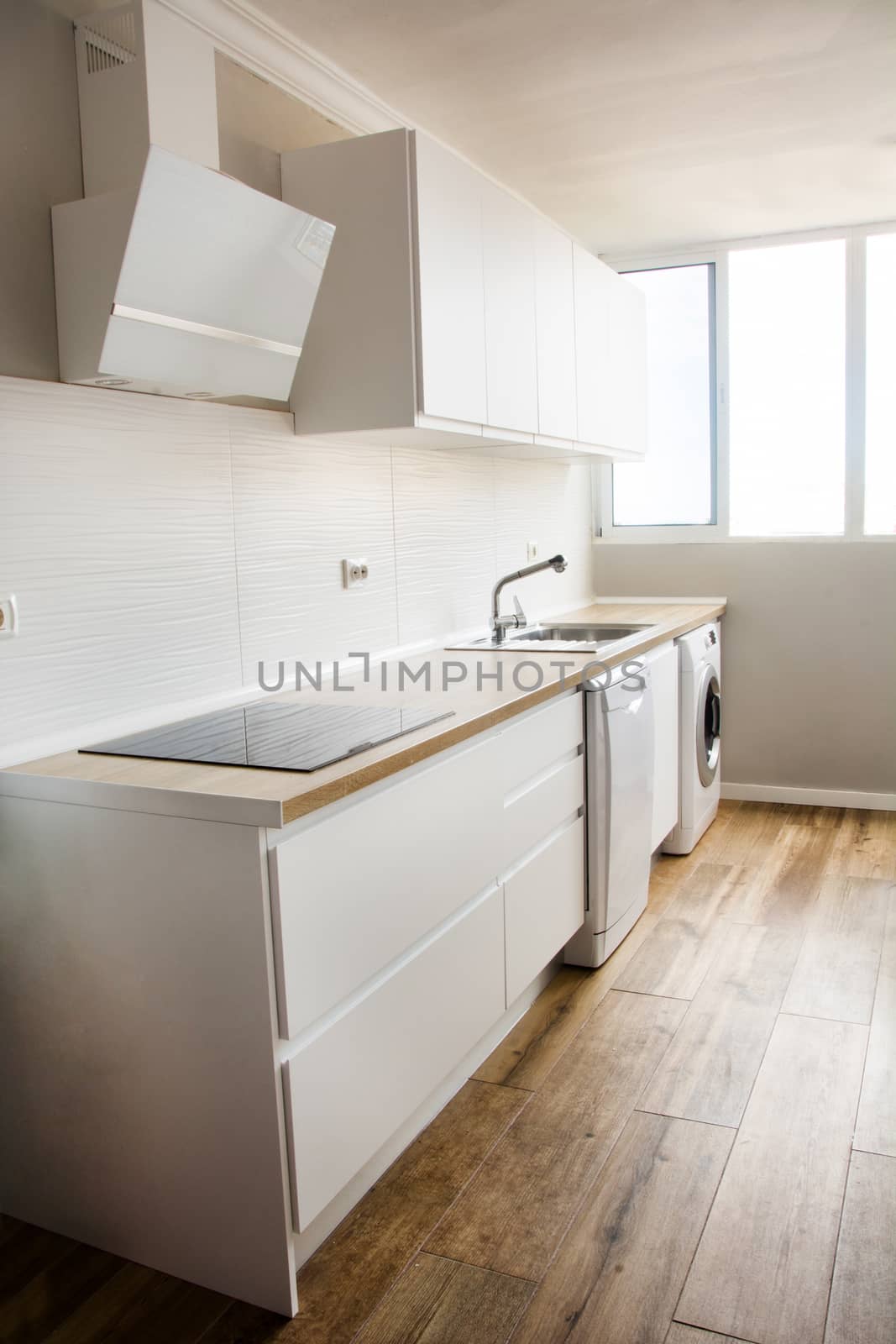 White modern kitchen with white furnitures and wooden floor by chandlervid85
