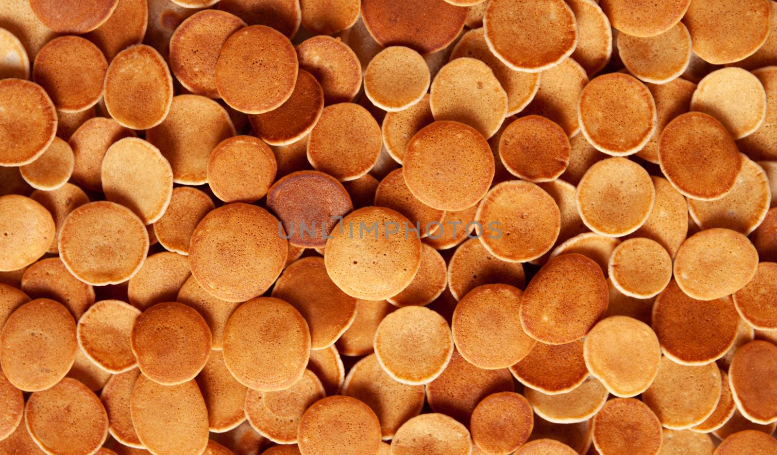 Trendy homemade breakfast, pancake cereal, mini pancakes on light plate on pink concrete background