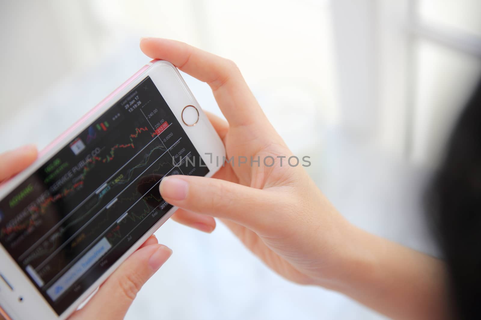 trading online on smartphone with bussiness woman hand by piyato